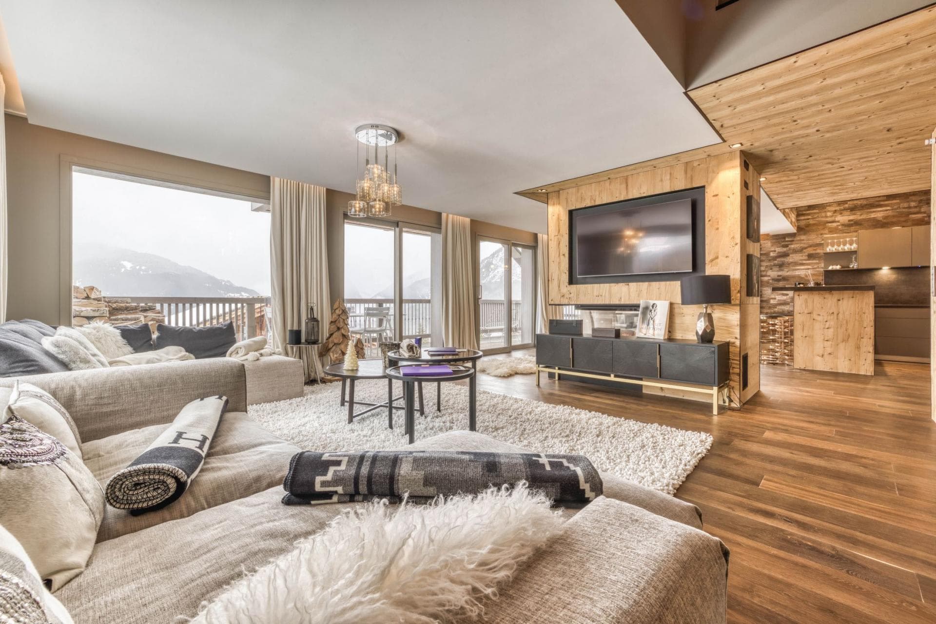 Living area with mountain-view balcony and integrated media wall
