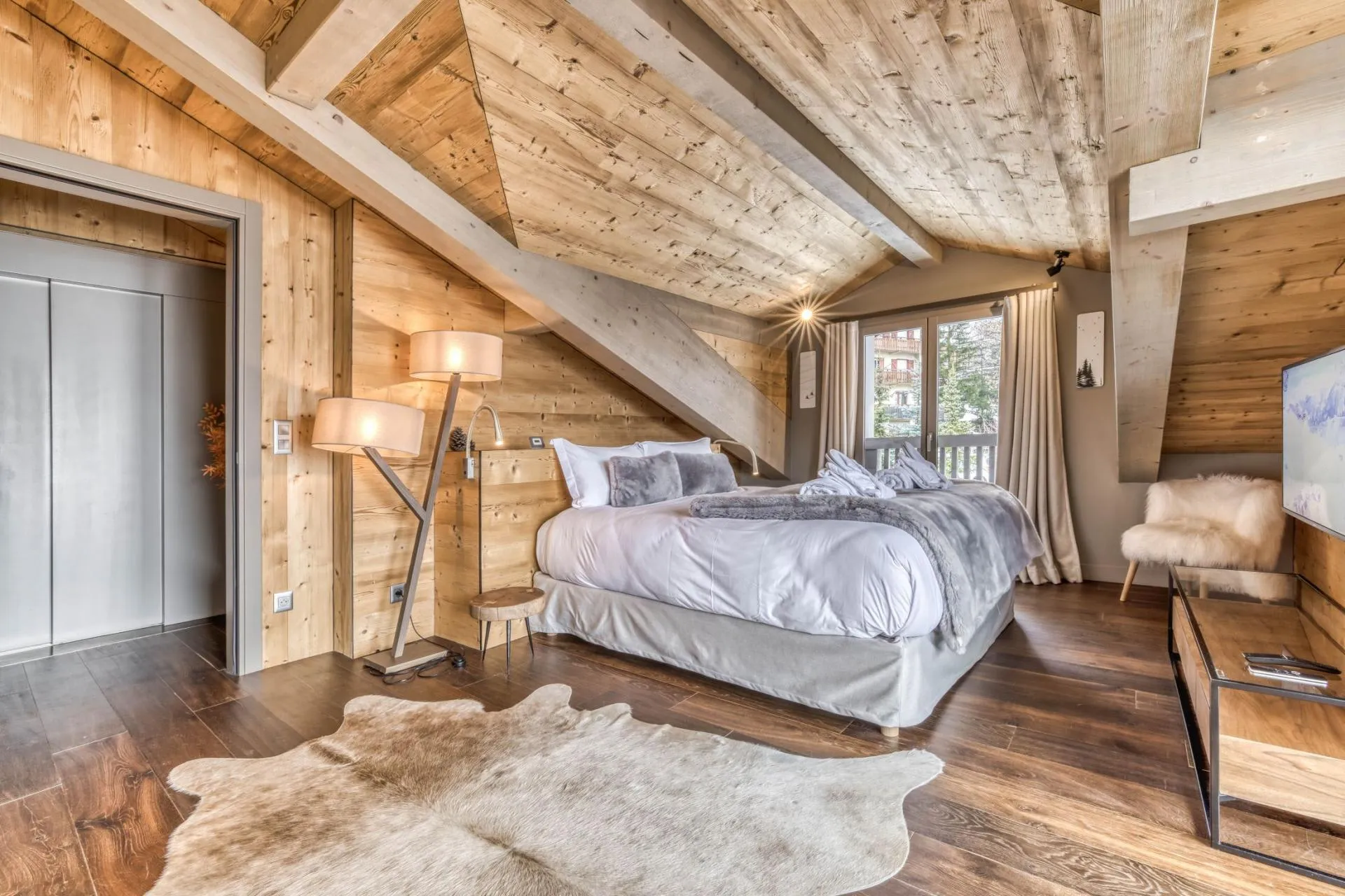 Master bedroom with timber ceiling and glazed balcony doors