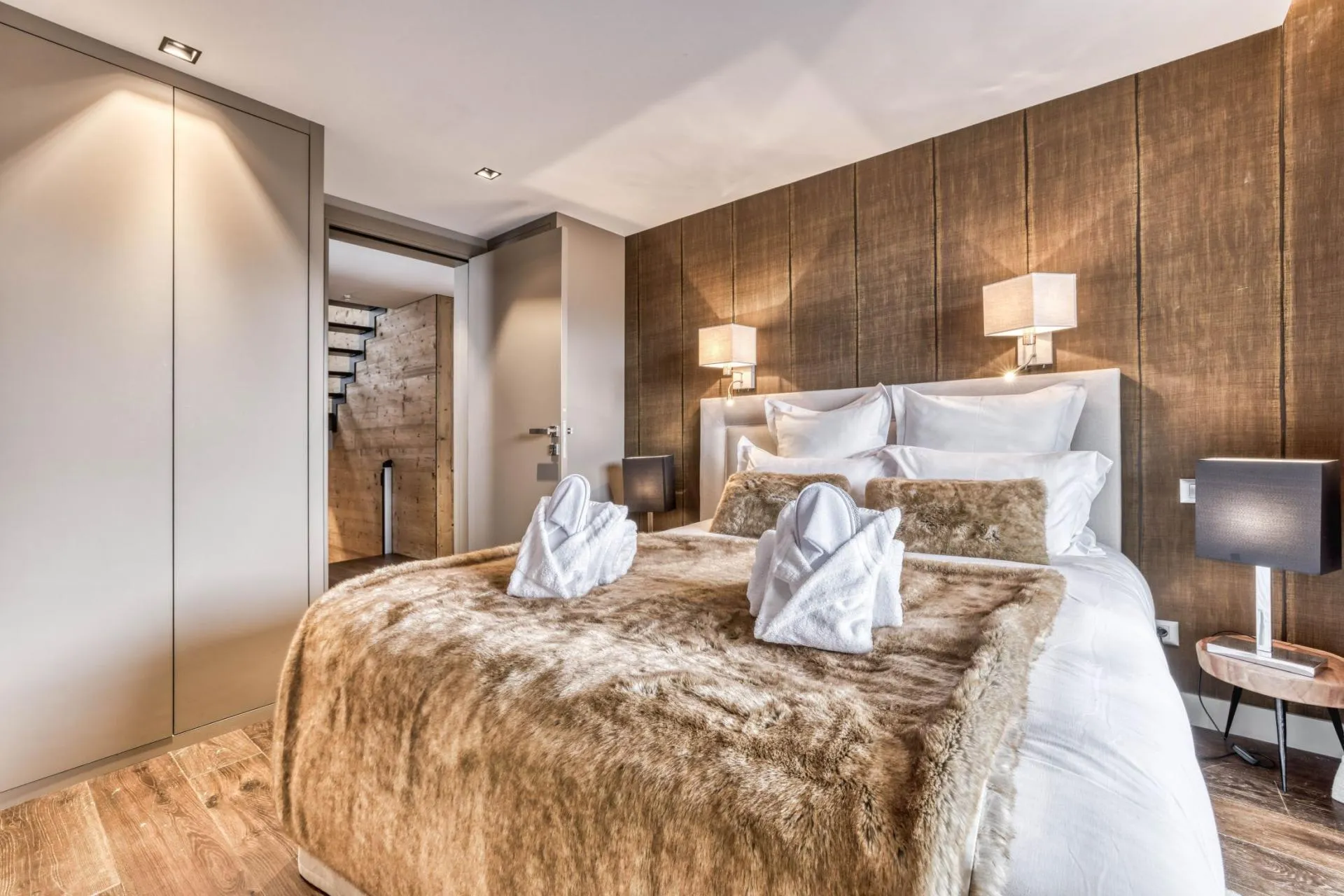 Double bedroom with timber wall panels and wardrobes