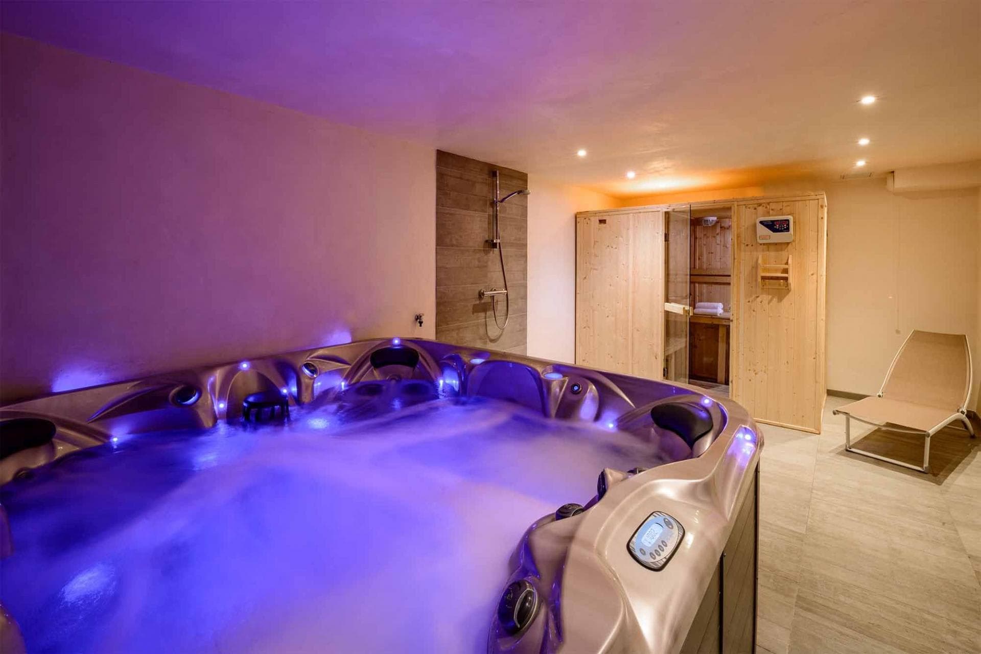 Indoor spa area with 6-person hot tub, wood sauna, and rainfall shower