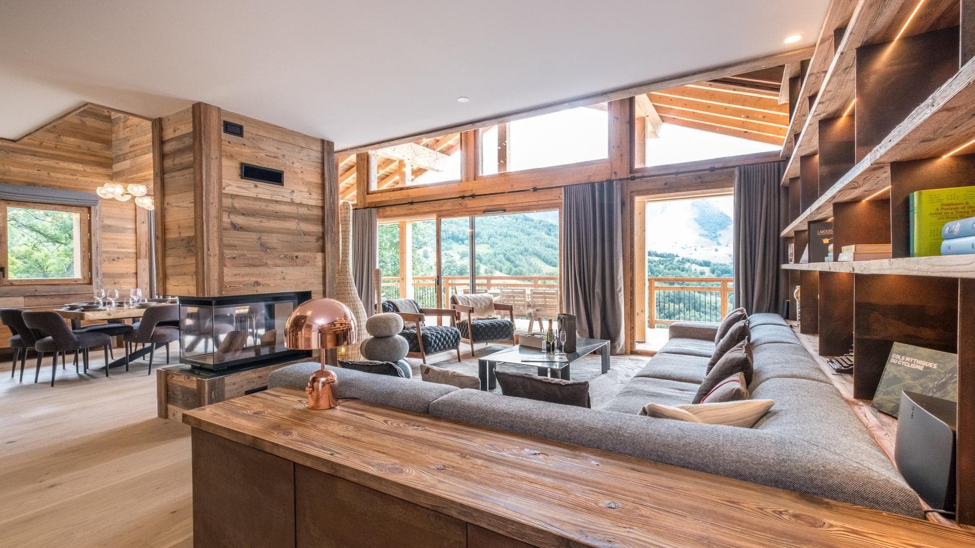 Open living area with glass-enclosed fireplace and floor-to-ceiling mountain views