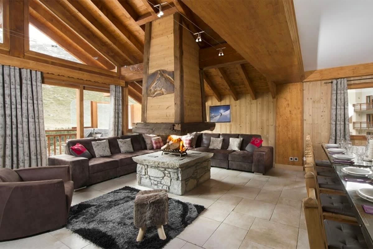 Open-plan living area with central stone fireplace and terrace access