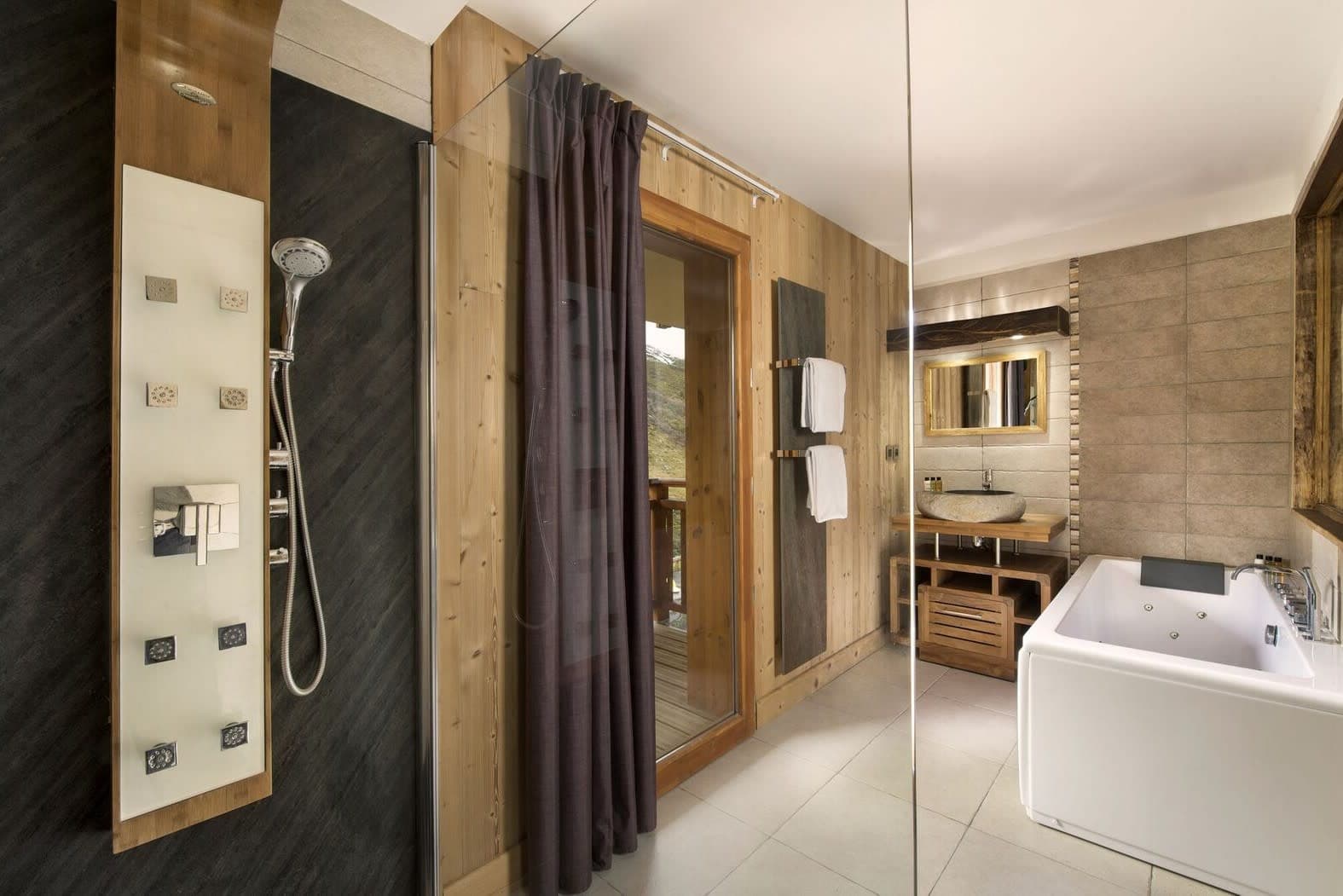 Bathroom with rainfall shower, body jets, jetted soaking tub, and balcony access