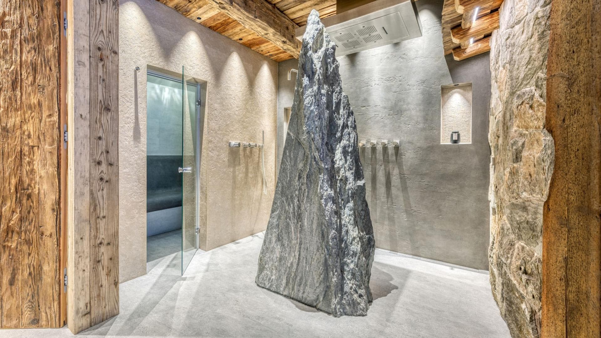 Spa area with walk-in stone shower and glass-door steam room