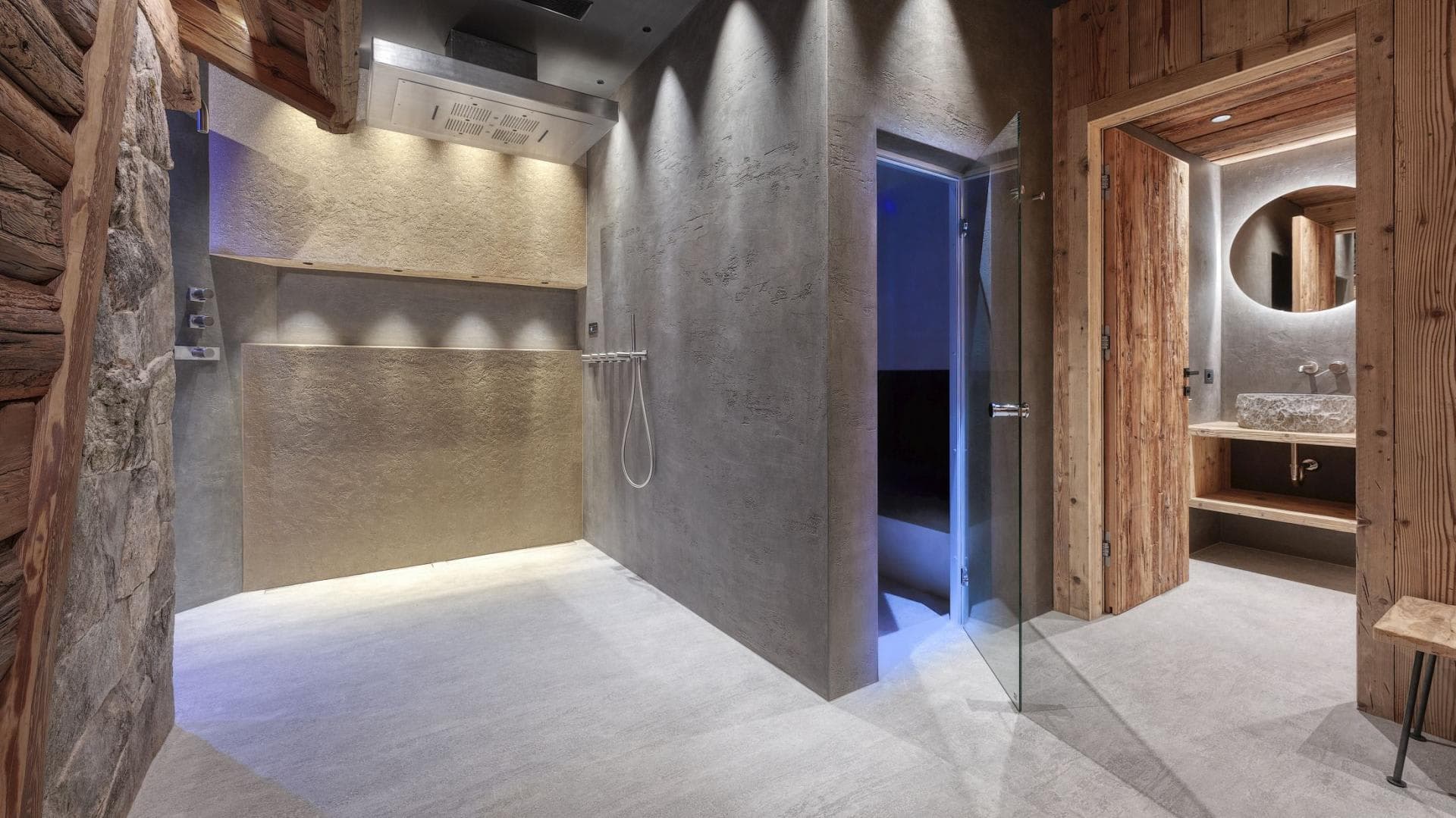 Spa area with rainfall shower, steam room, and stone vessel sink