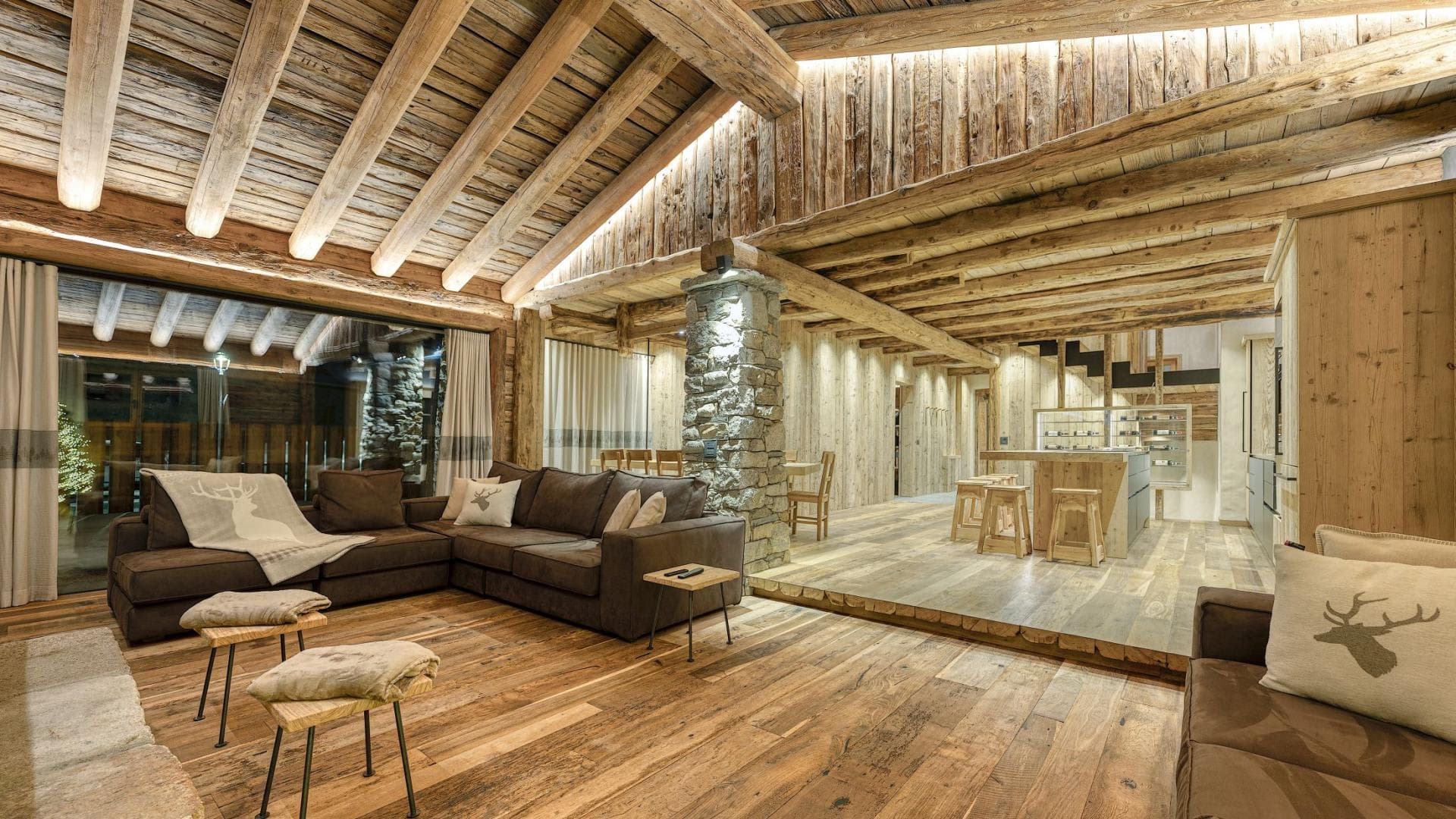 Open-plan living area with vaulted timber ceilings and breakfast bar seating