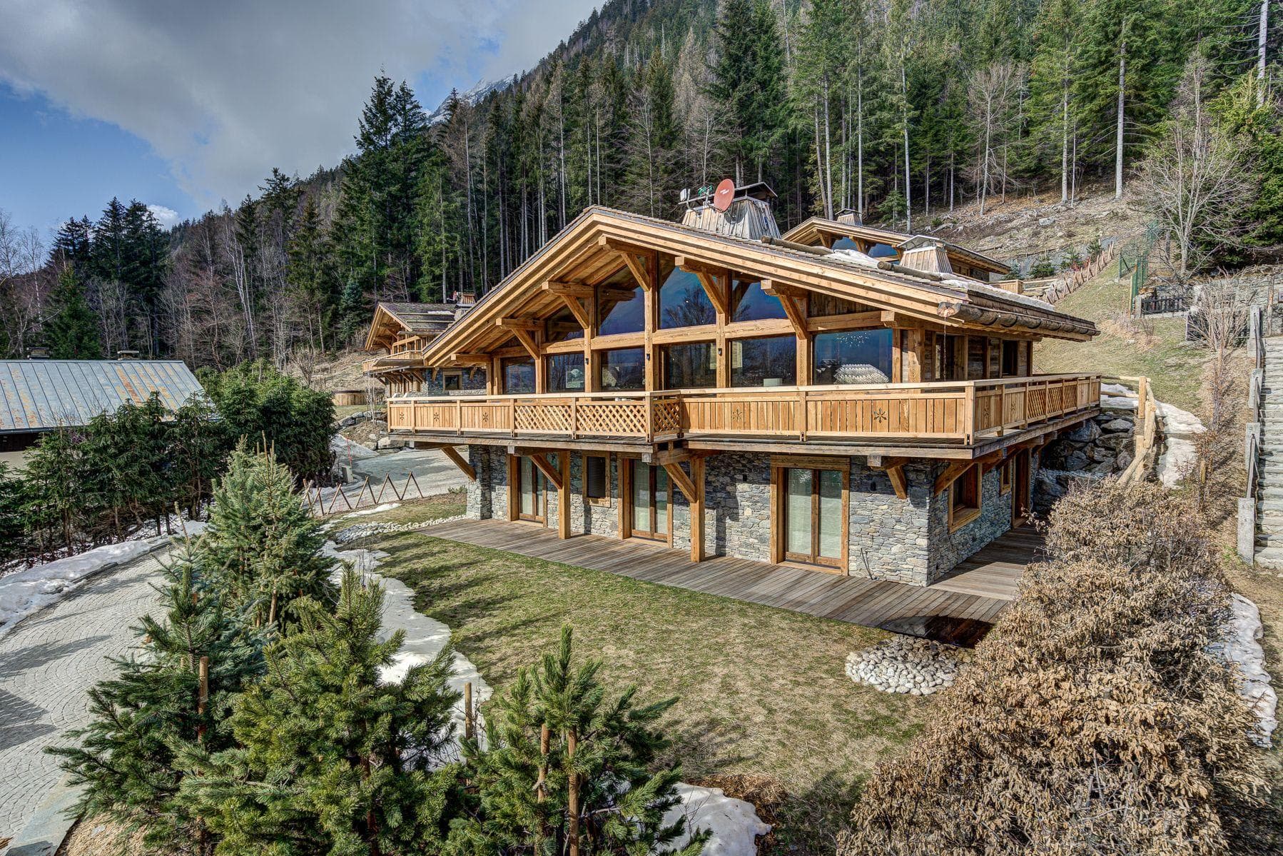 Chalet exterior with wrap-around balcony and stone-paved patio area