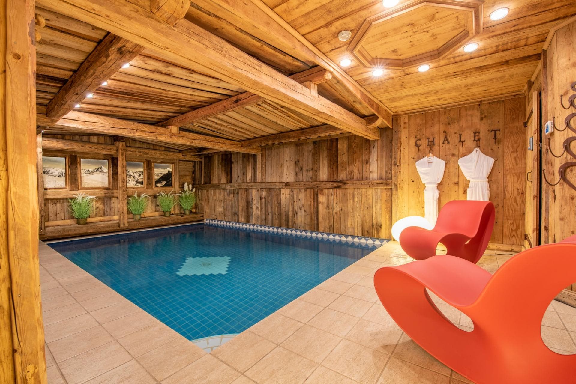 Indoor pool area with reclaimed wood paneling and lounge seating