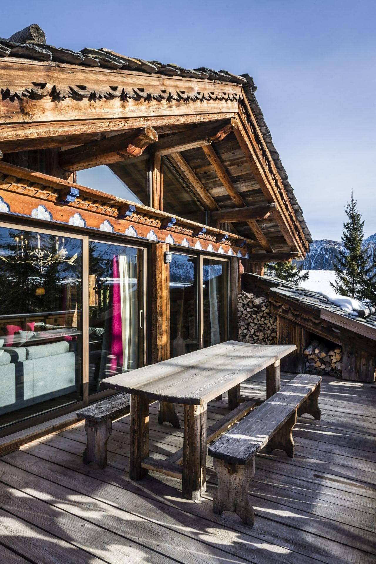 Chalet sun deck with bench seating and stored firewood