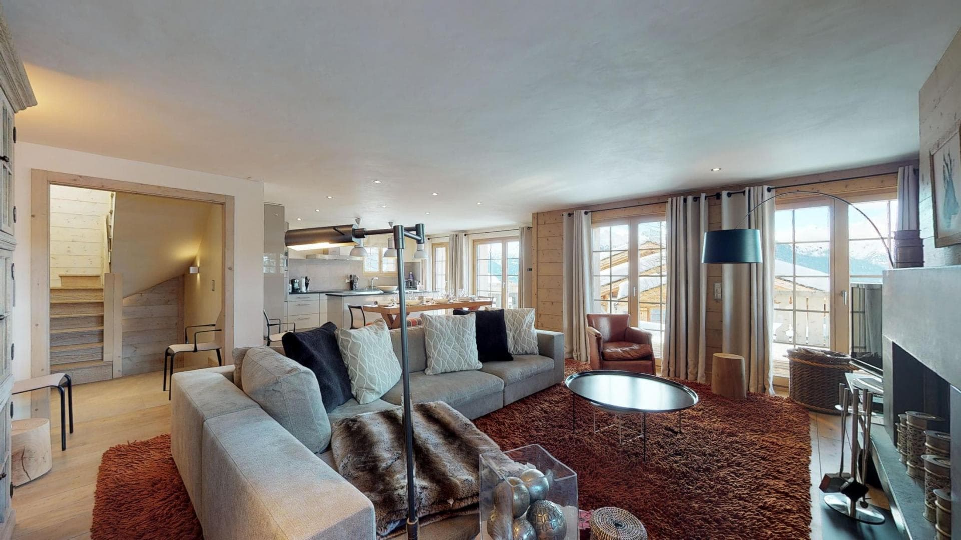 Open-plan living area with wood-burning fireplace and mountain-view balcony