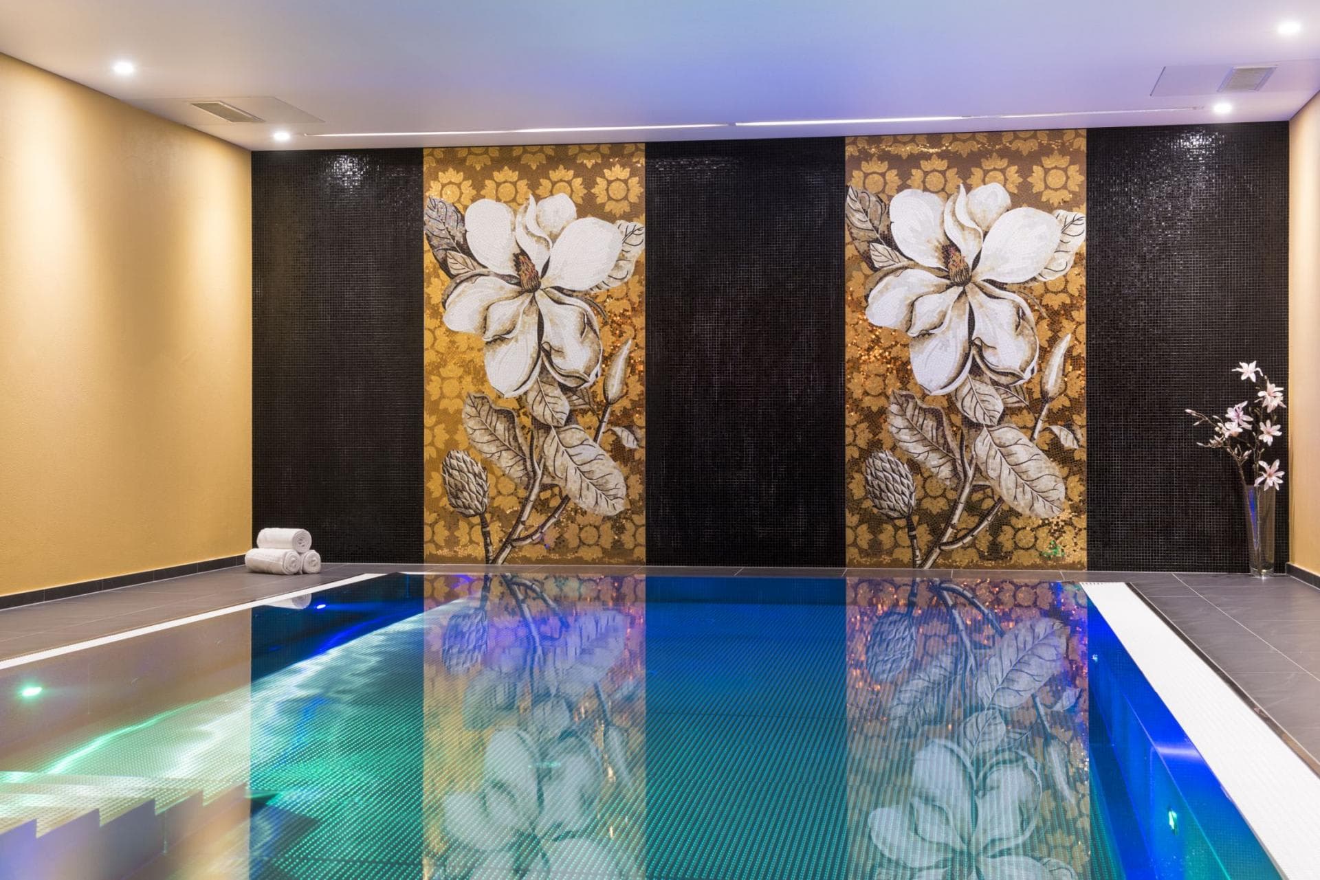 Indoor pool featuring mosaic flower murals and integrated underwater lighting