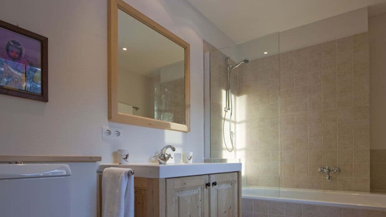 Bathroom featuring single vanity and soaking tub with glass-screen shower