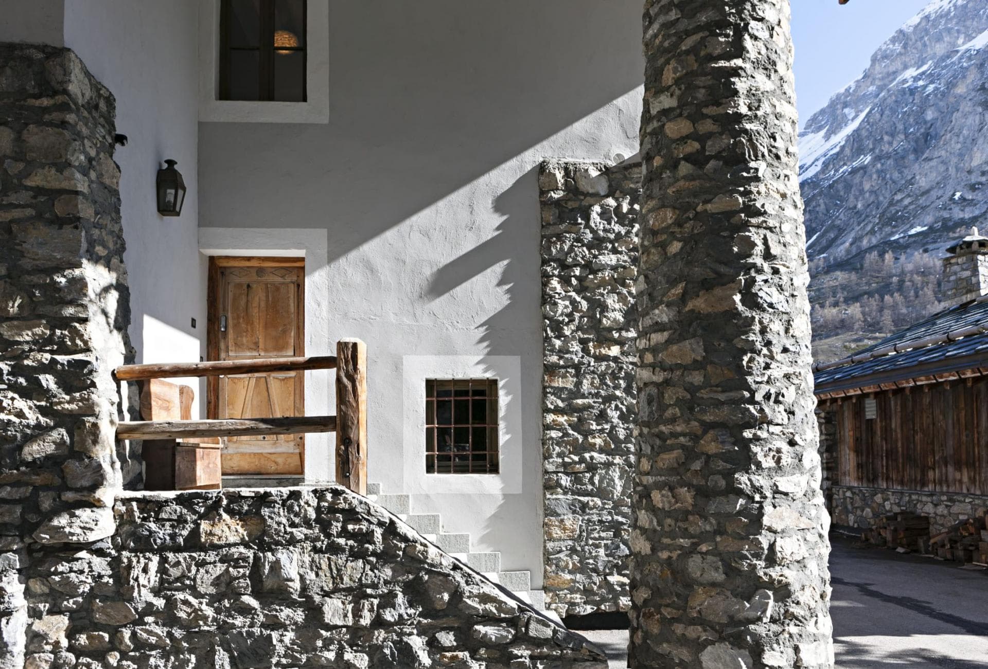 Stone entryway with hand-carved wooden door and mountain peak views