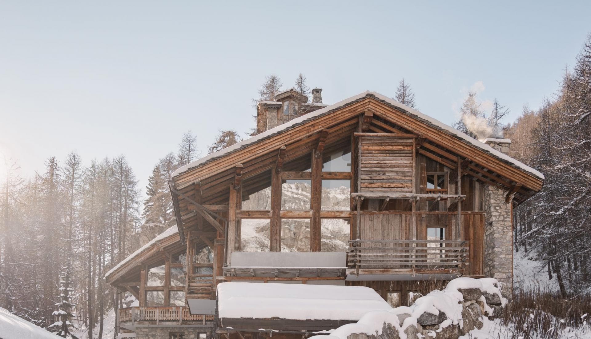 Chalet exterior with timber facade and floor-to-ceiling mountain view windows