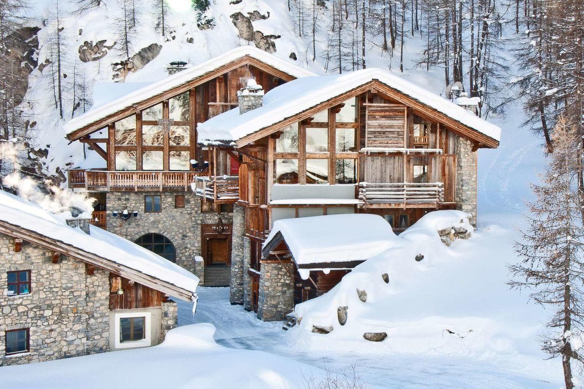 Ski-in, ski-out timber chalet with stone exterior and floor-to-ceiling windows