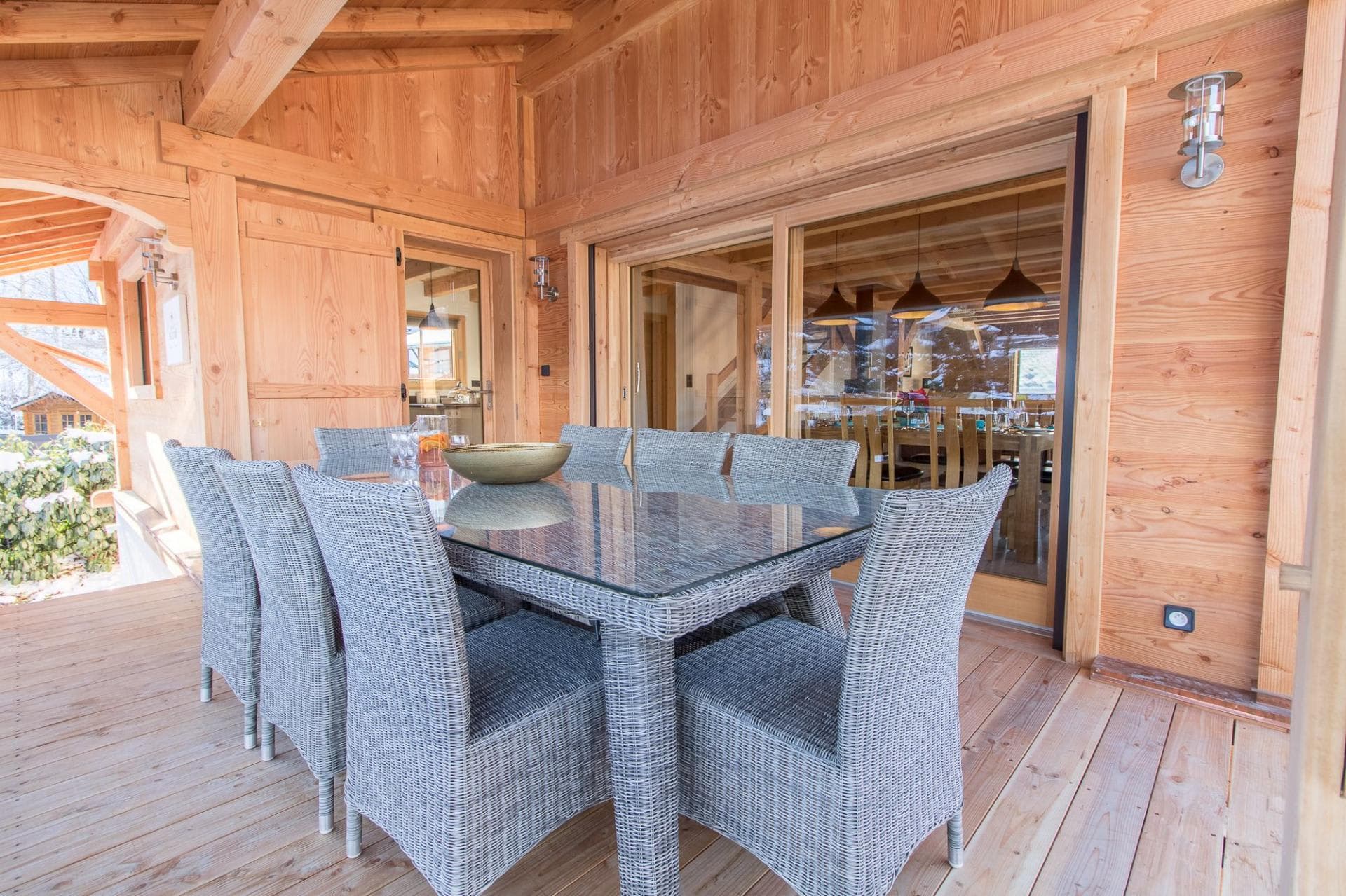 Covered timber terrace with wicker dining table for 8