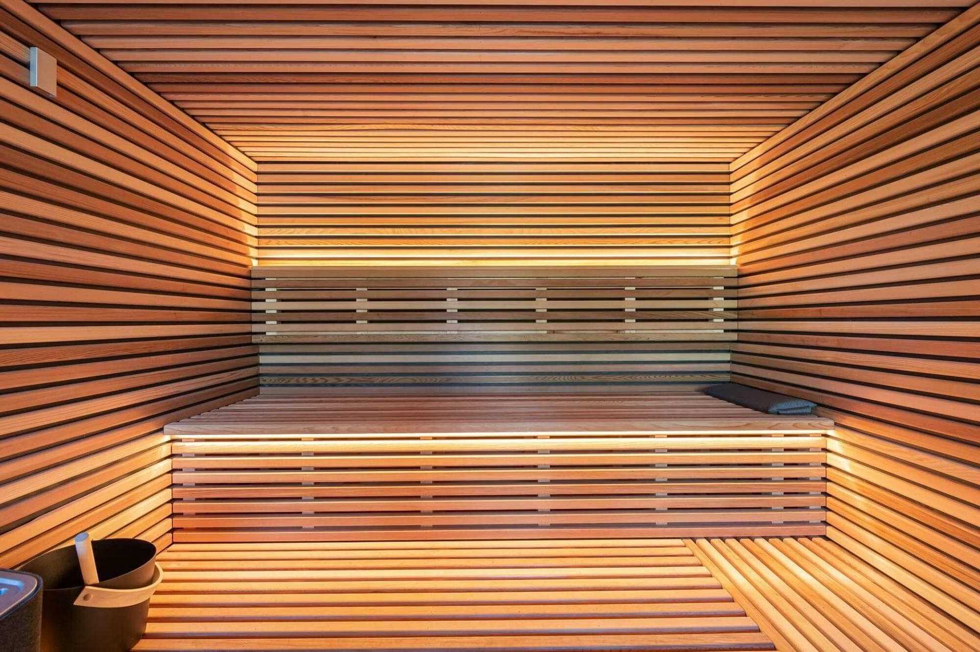 Cedar-lined sauna with tiered bench seating and ambient LED backlighting