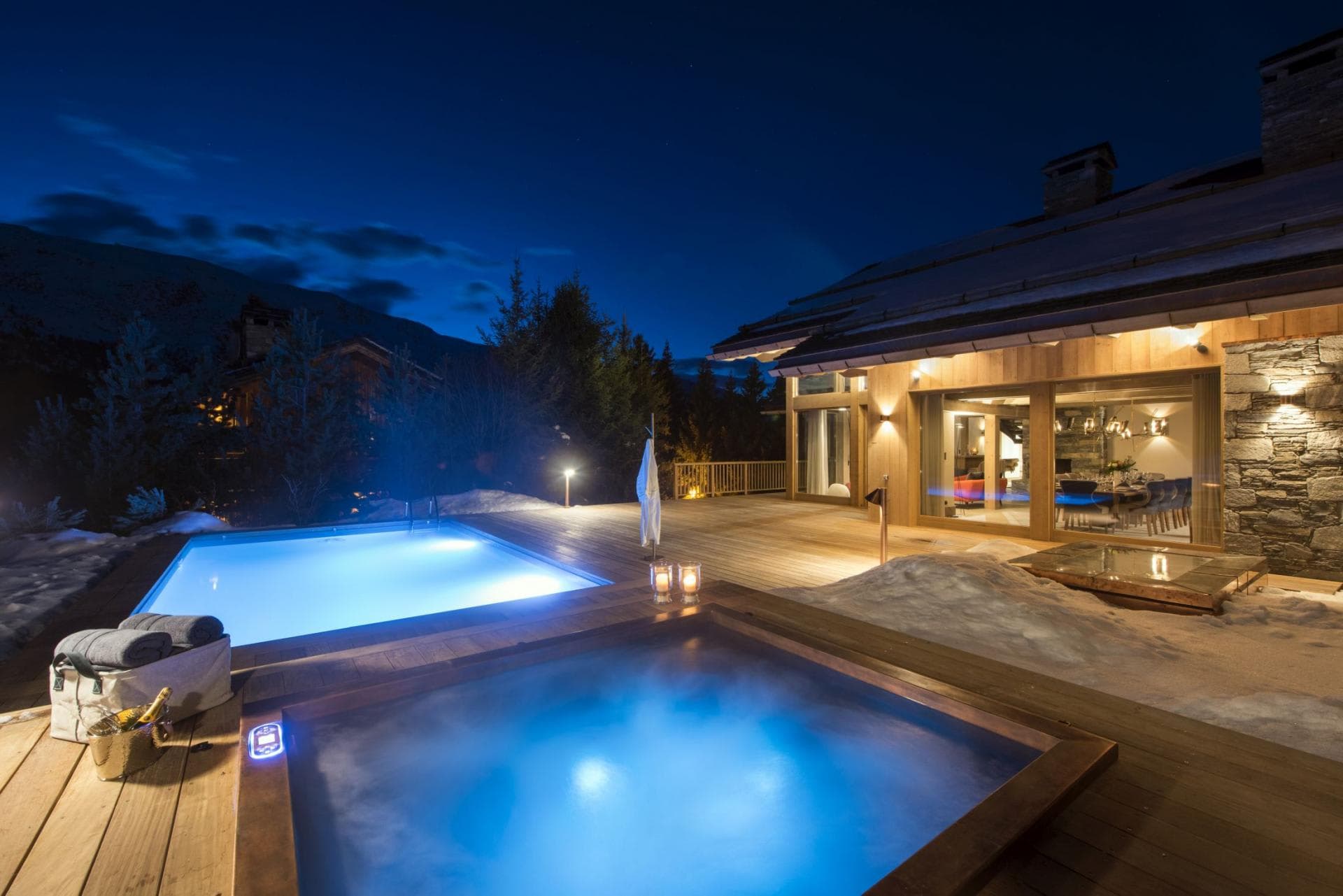 Heated outdoor pool and hot tub on wood deck with mountain views