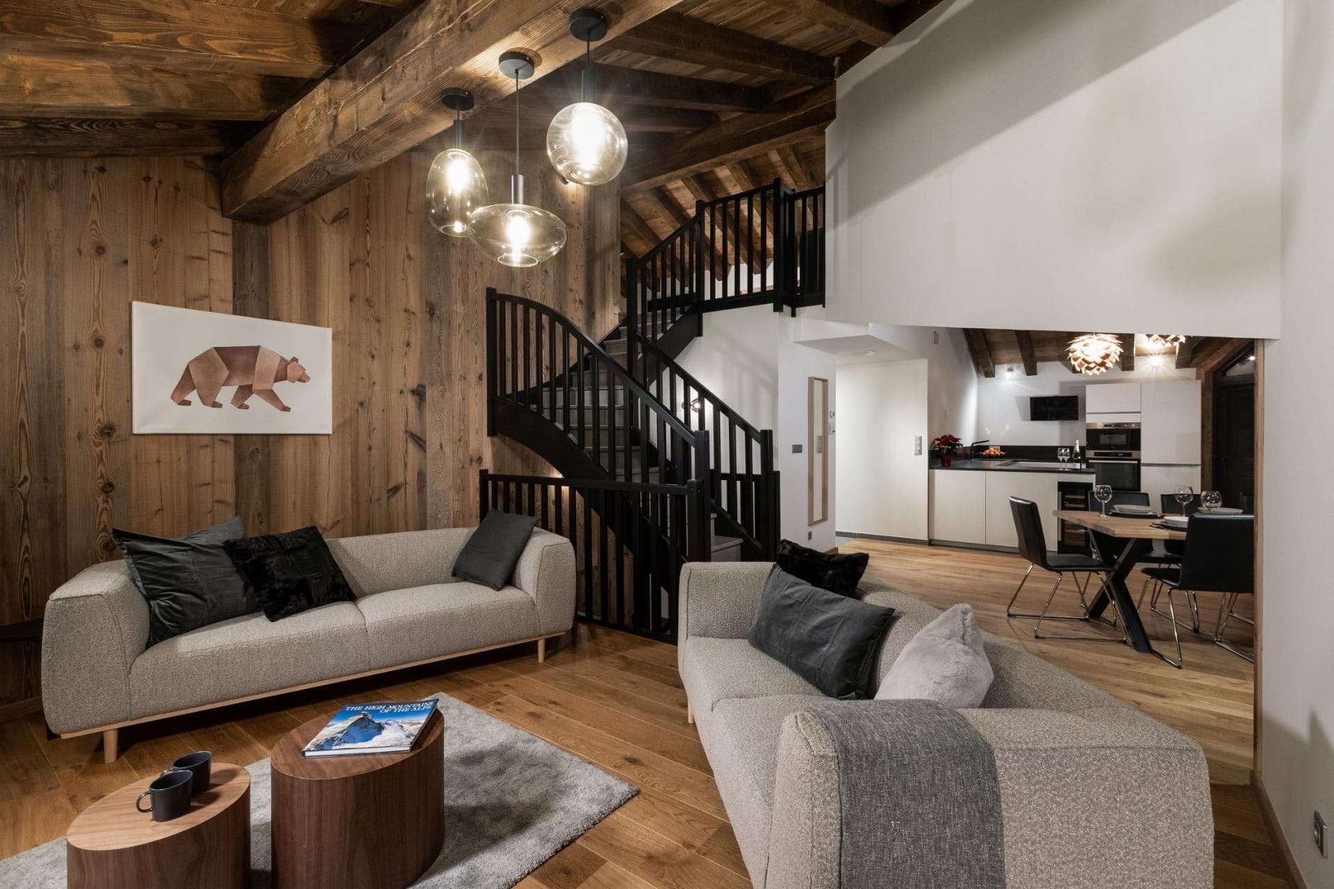 Living room with wood-paneled walls and staircase to upper level