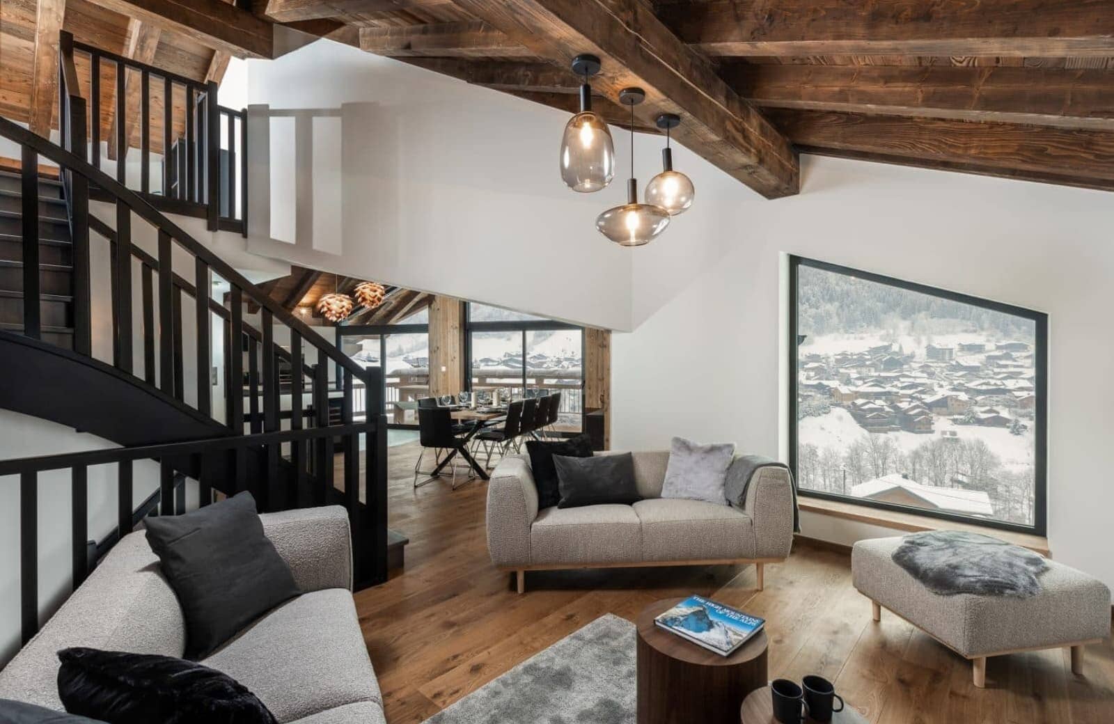 Living area with exposed timber beams and mountain village views