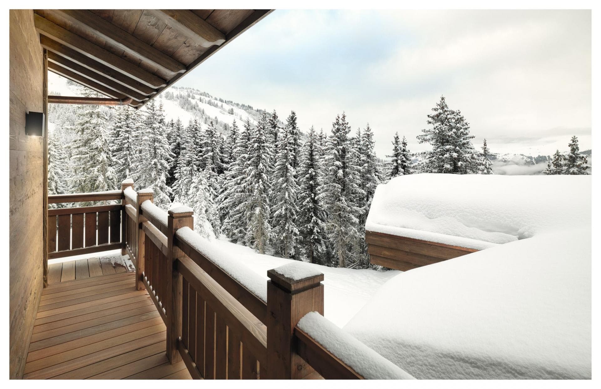 Covered wooden balcony with direct views of snow-covered pine forest