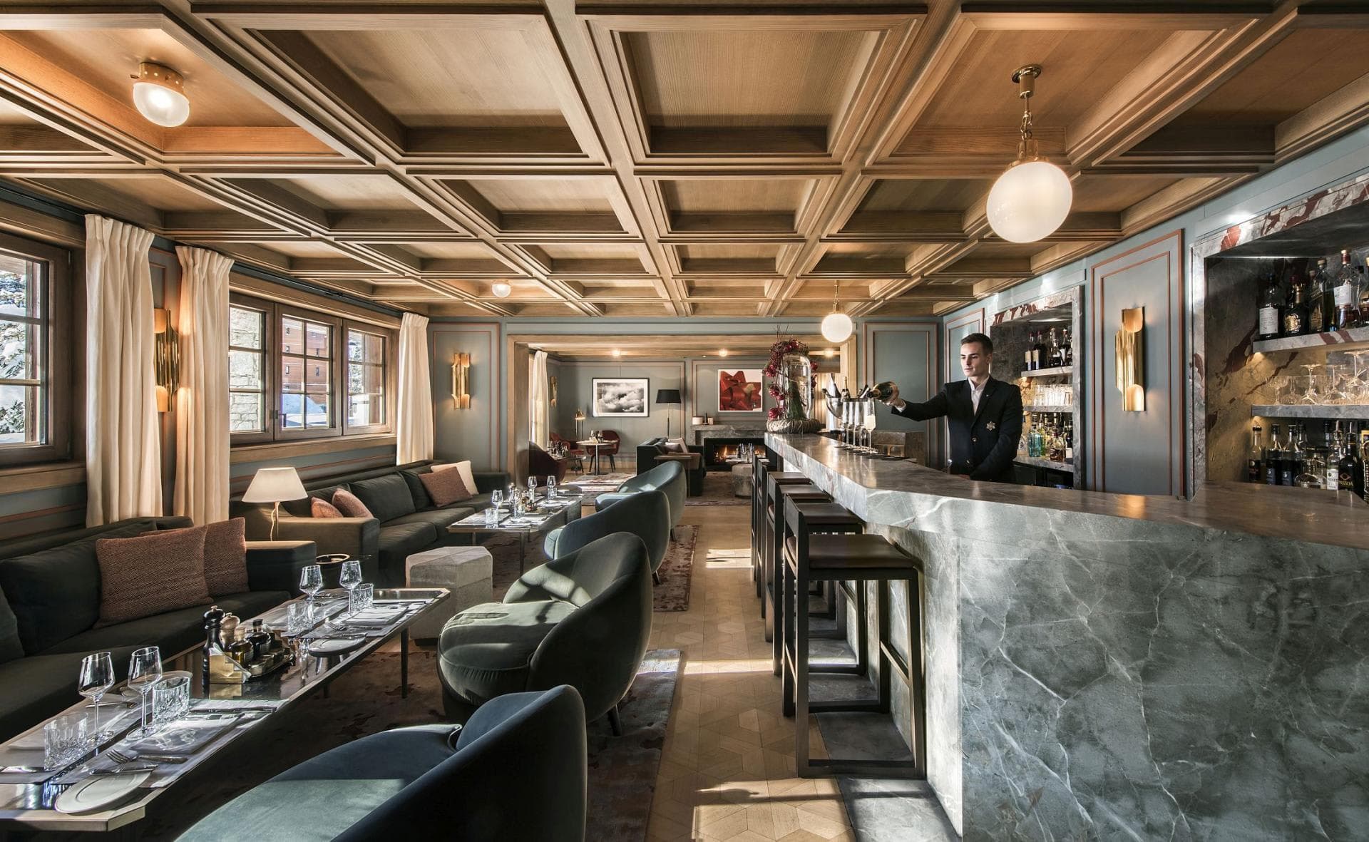 Lounge and cocktail bar with marble counter and coffered wood ceiling