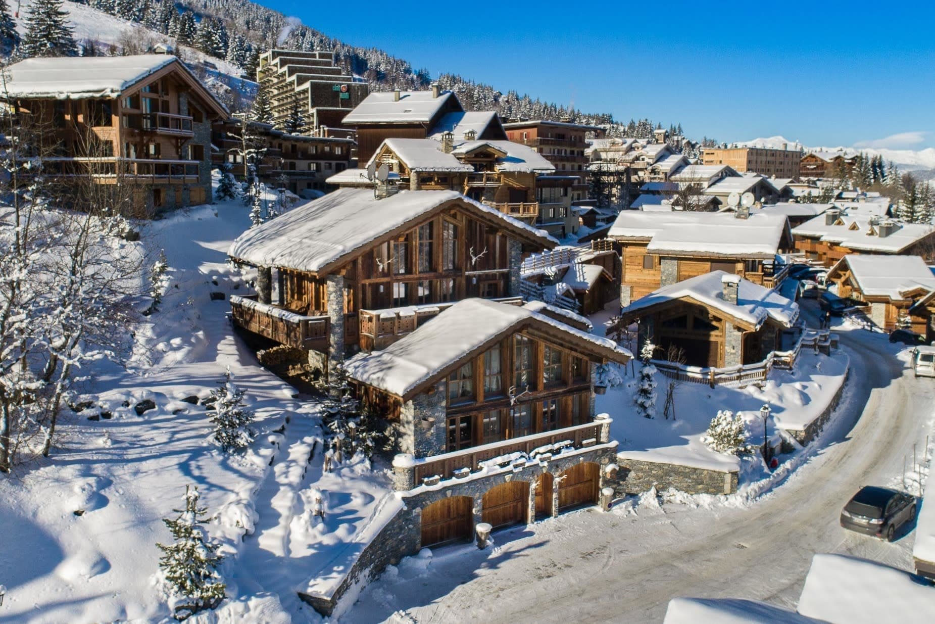 Ski-in chalet exterior with private three-car garage and balcony