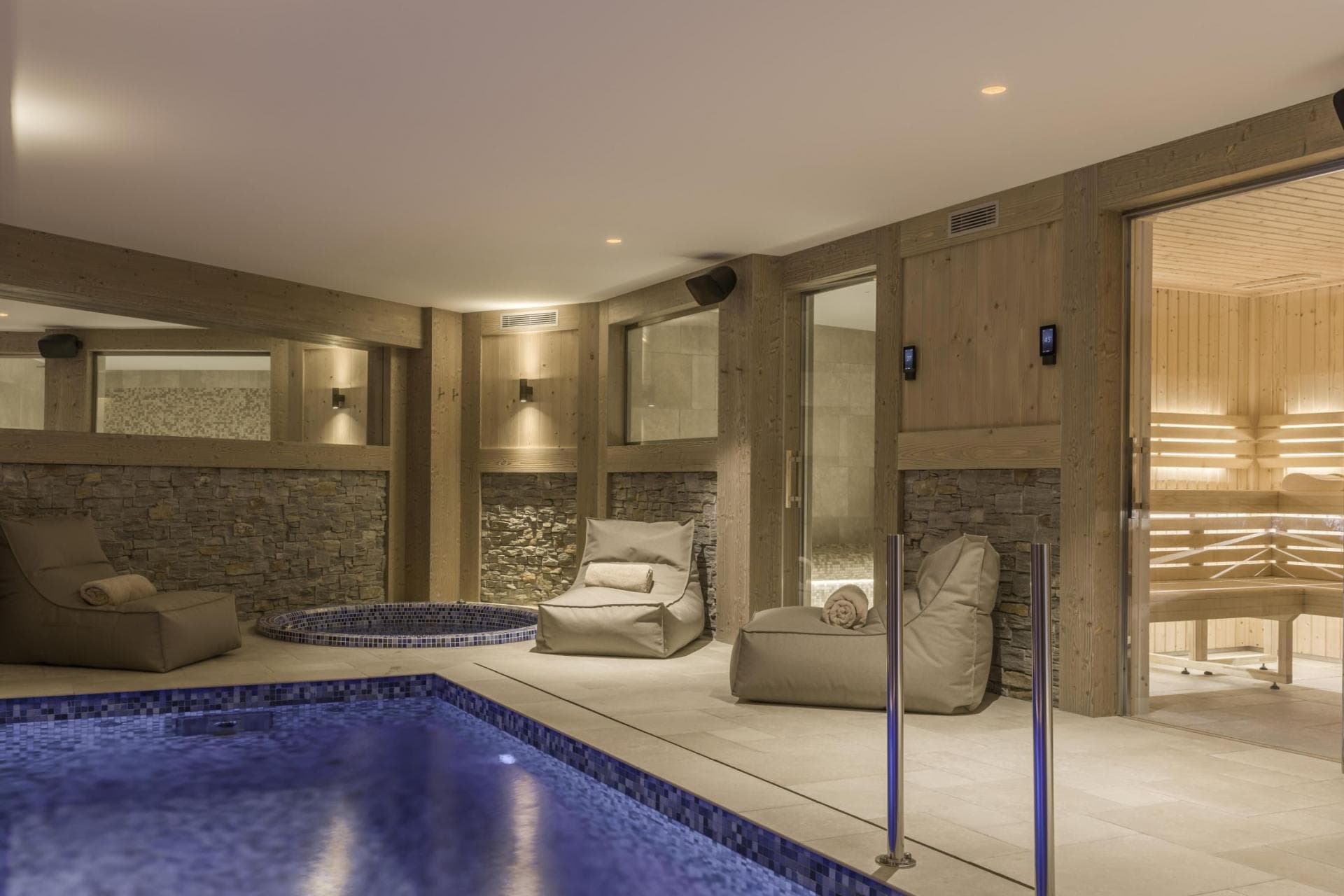 Wellness area with indoor pool, circular hot tub, and wood-paneled sauna