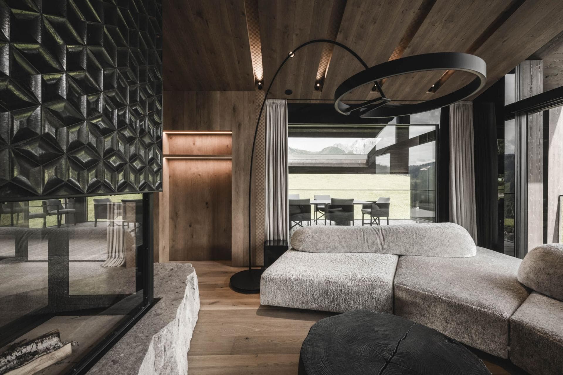 Living room with textured tile fireplace and floor-to-ceiling mountain views