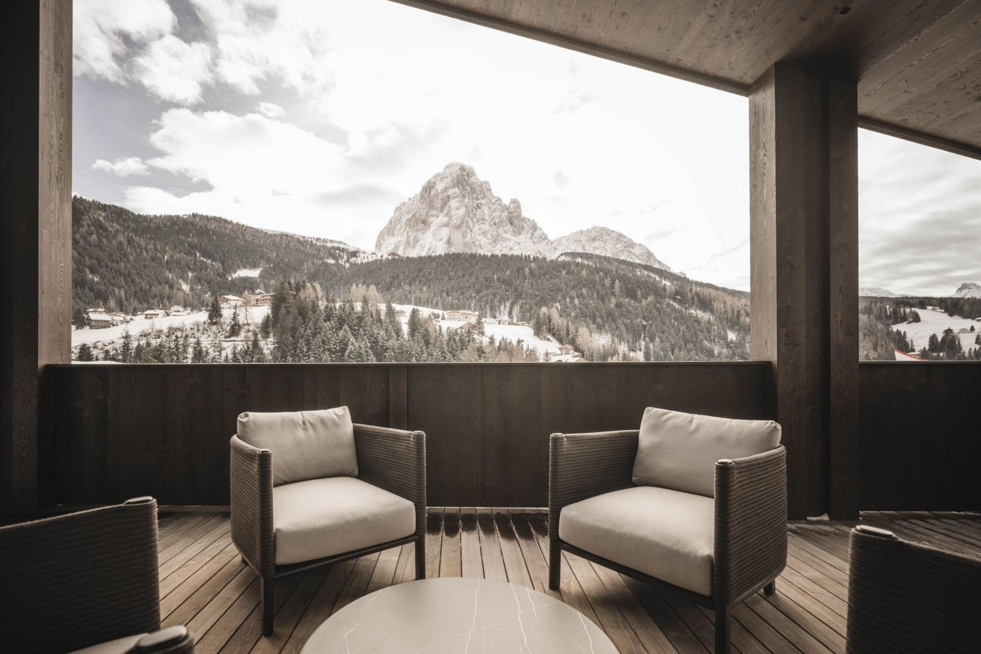 Covered terrace with armchair seating and alpine mountain views
