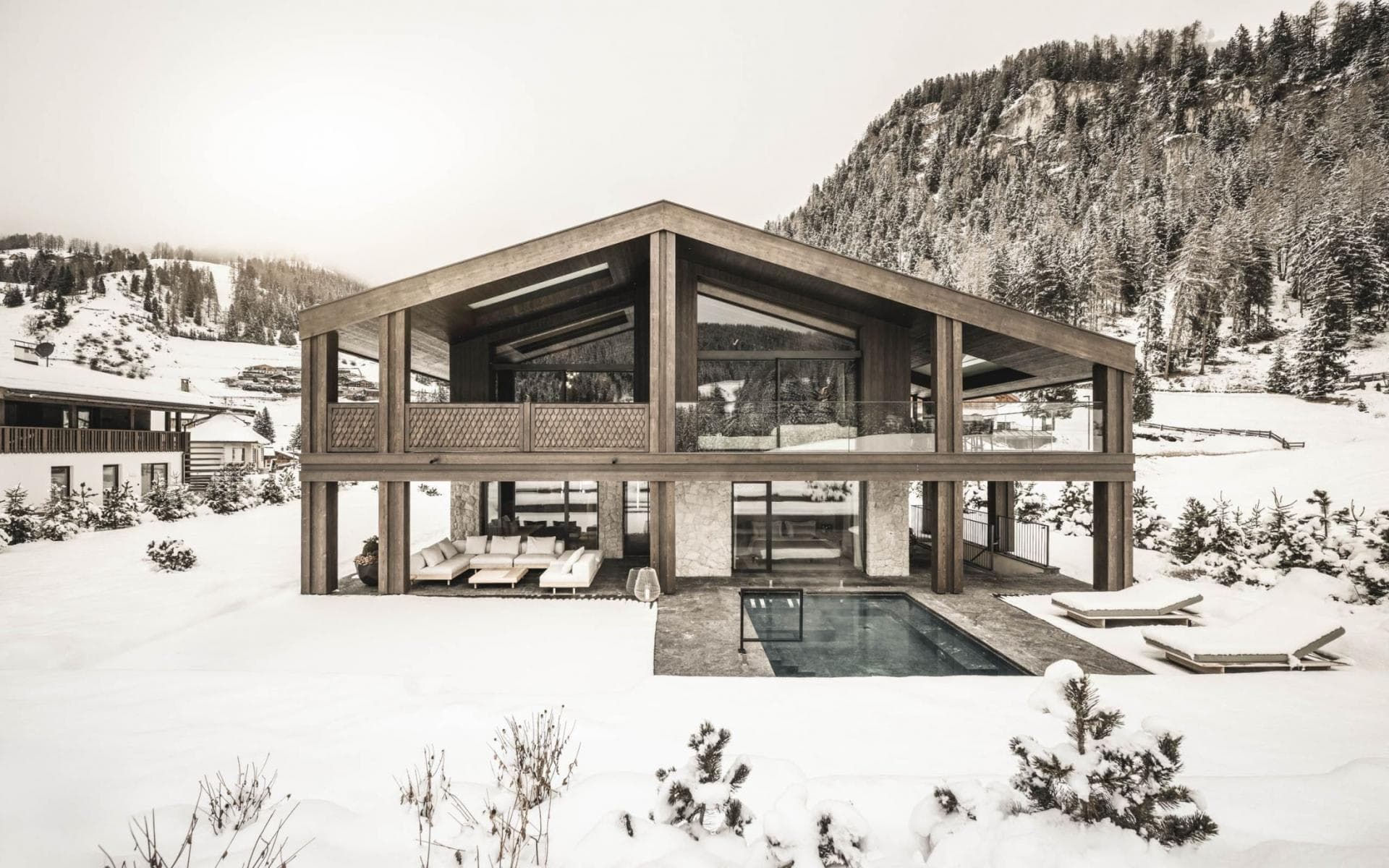 Timber chalet exterior with heated outdoor pool and covered lounge