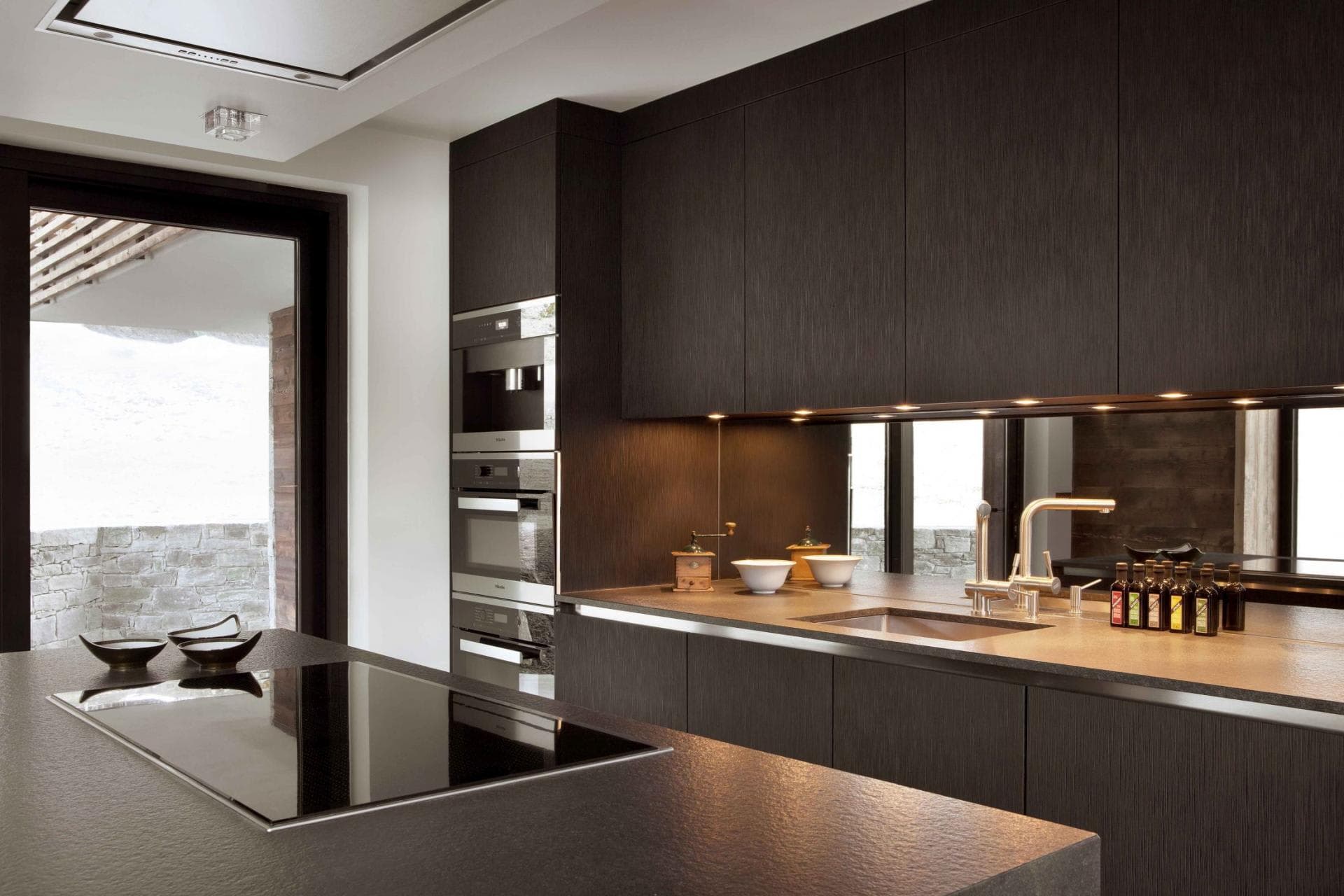 Kitchen featuring Miele triple wall ovens and integrated induction cooktop