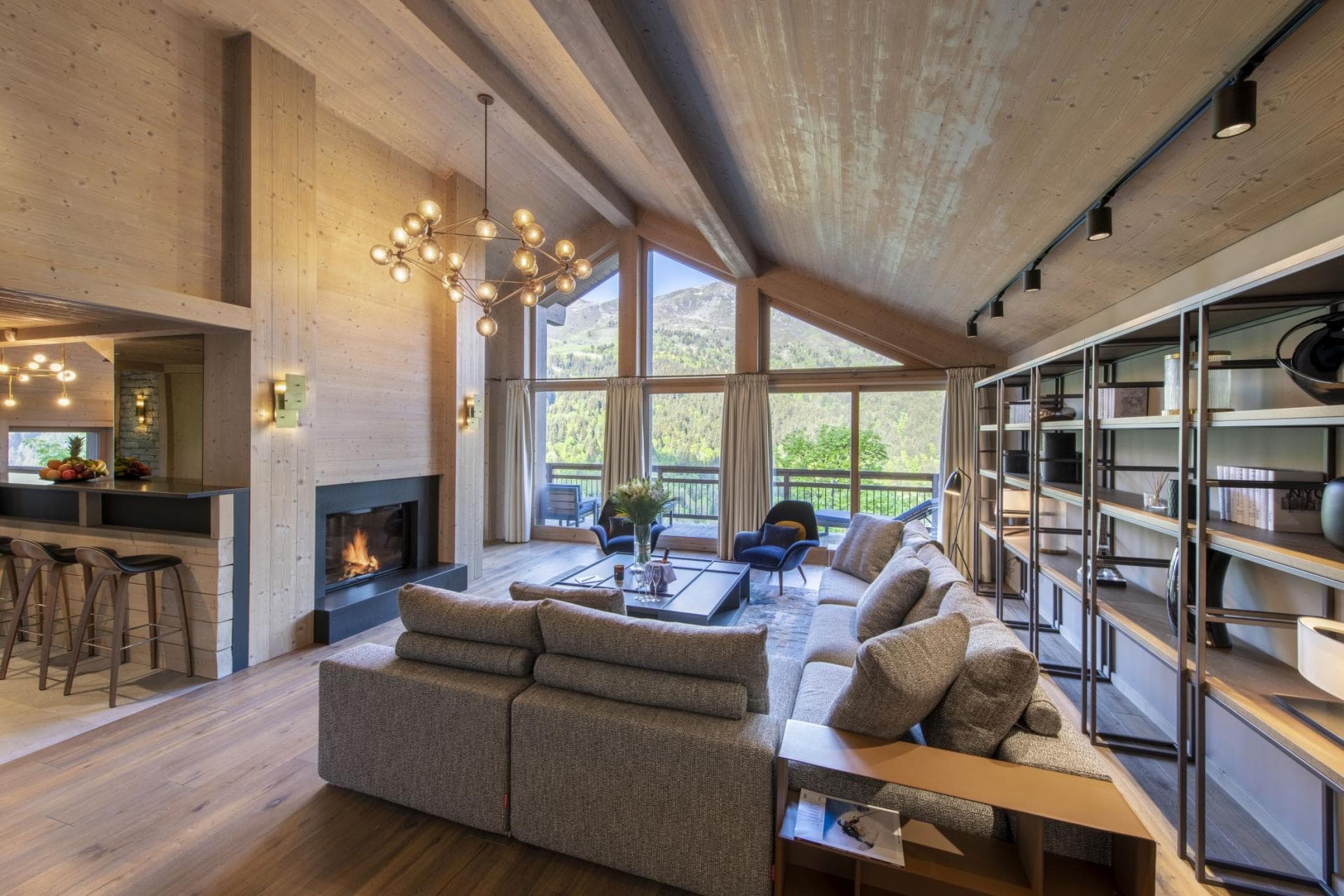 Living area with wood-burning fireplace and floor-to-ceiling mountain views