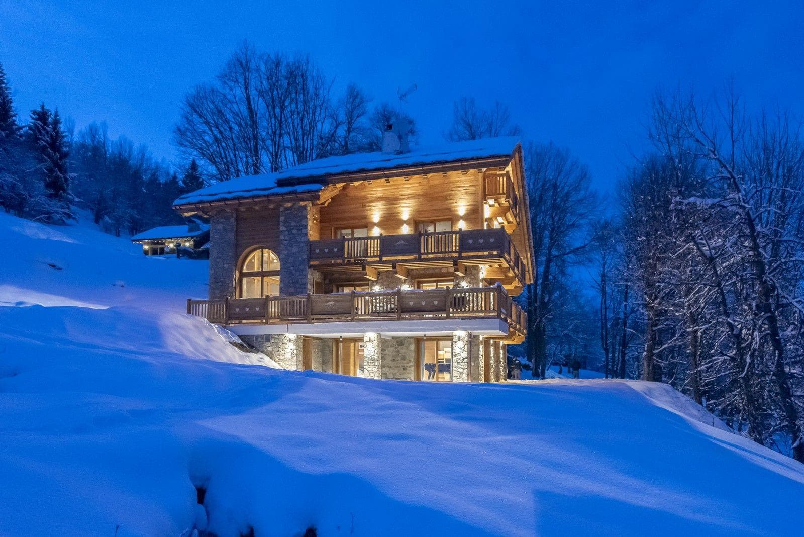Ski-in, ski-out timber chalet with wrap-around balconies and stone masonry