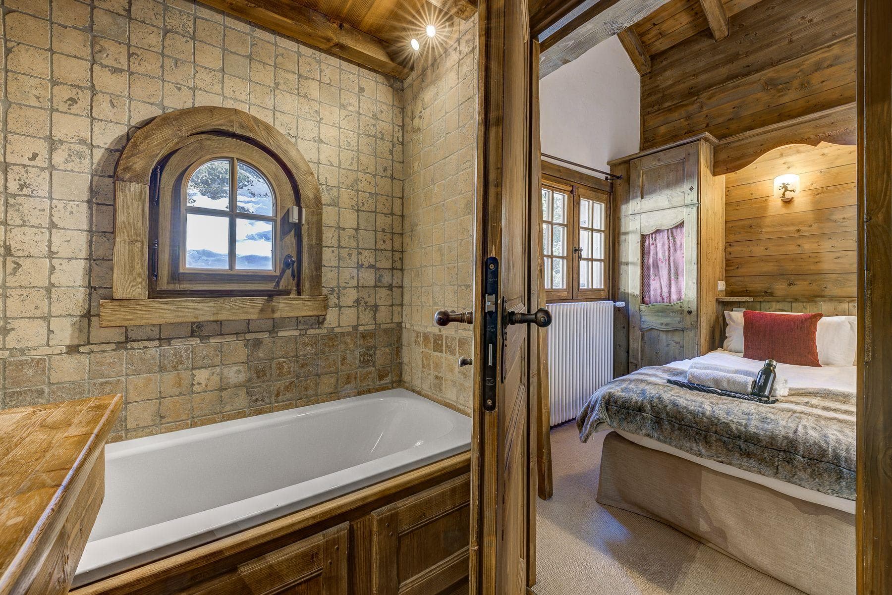 Ensuite bathroom with soaking tub and view of bedroom