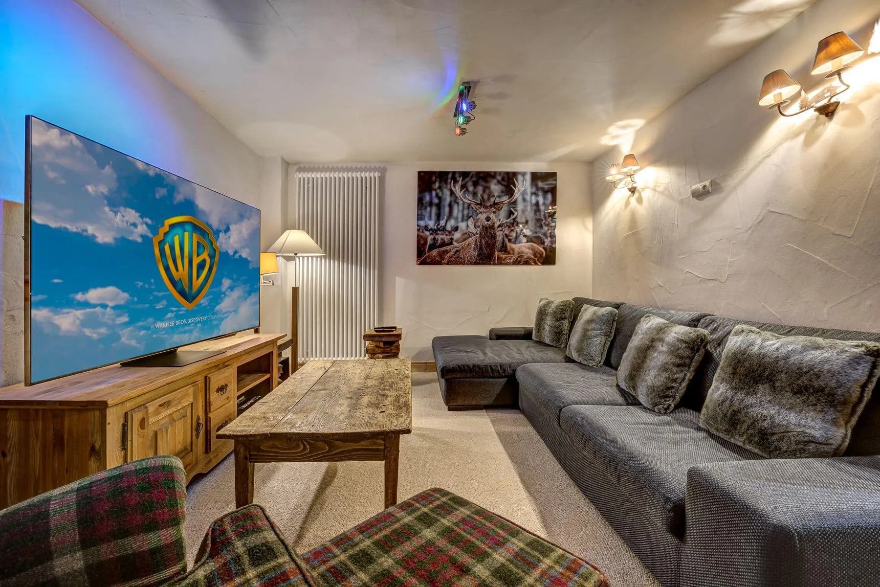 Combined TV and games room with a large-screen television and sectional seating
