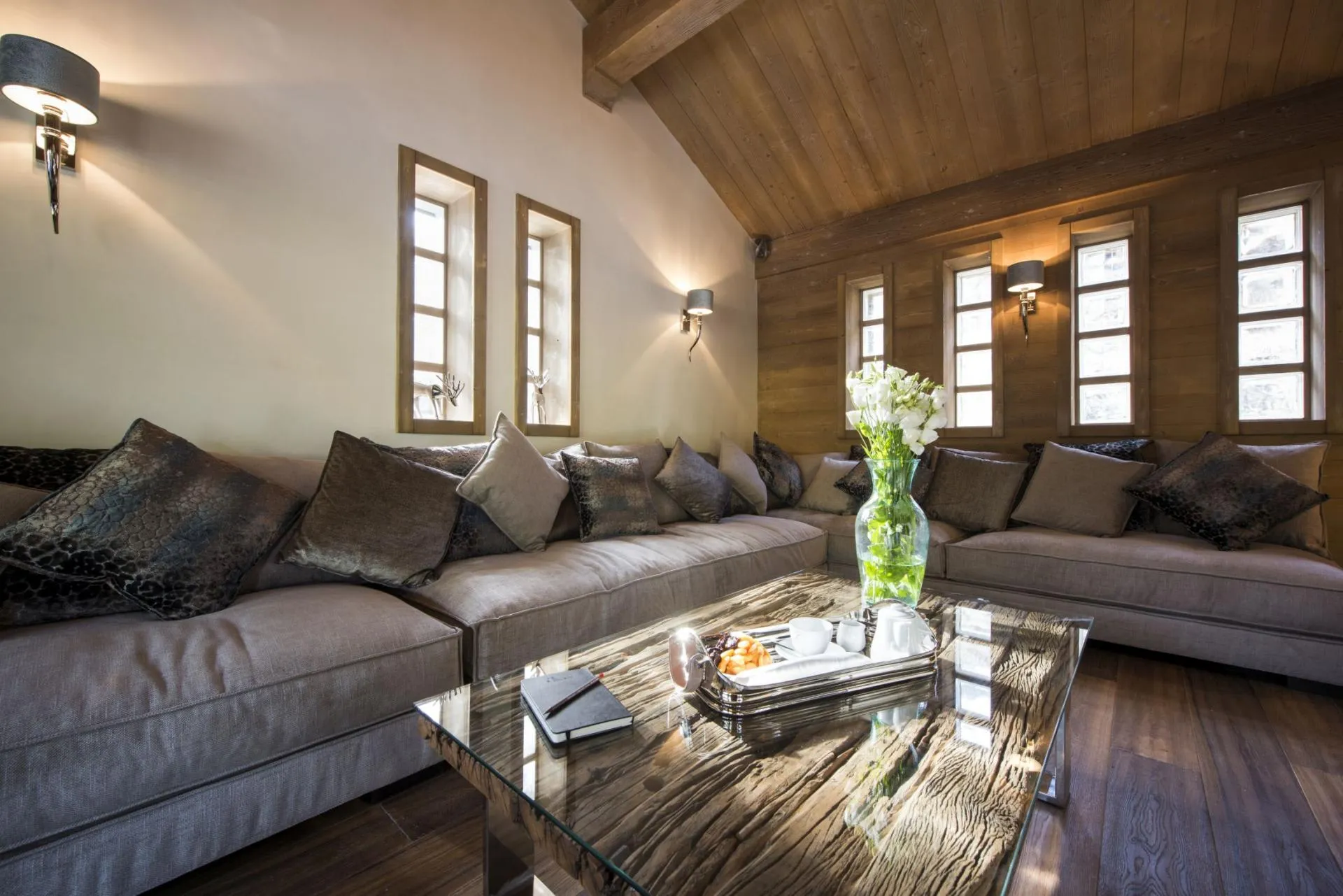 Living area featuring L-shaped sectional and vaulted wood plank ceiling