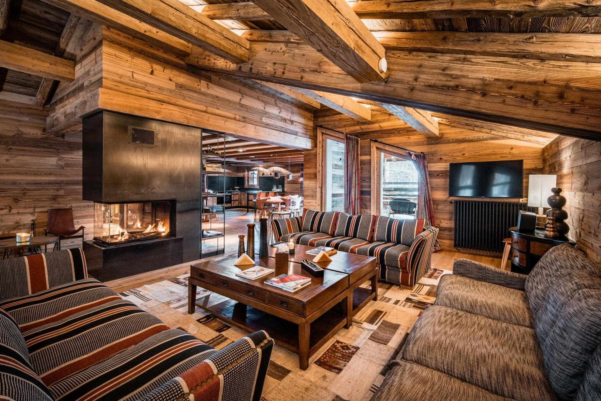 Living area with three-sided fireplace and reclaimed timber beams