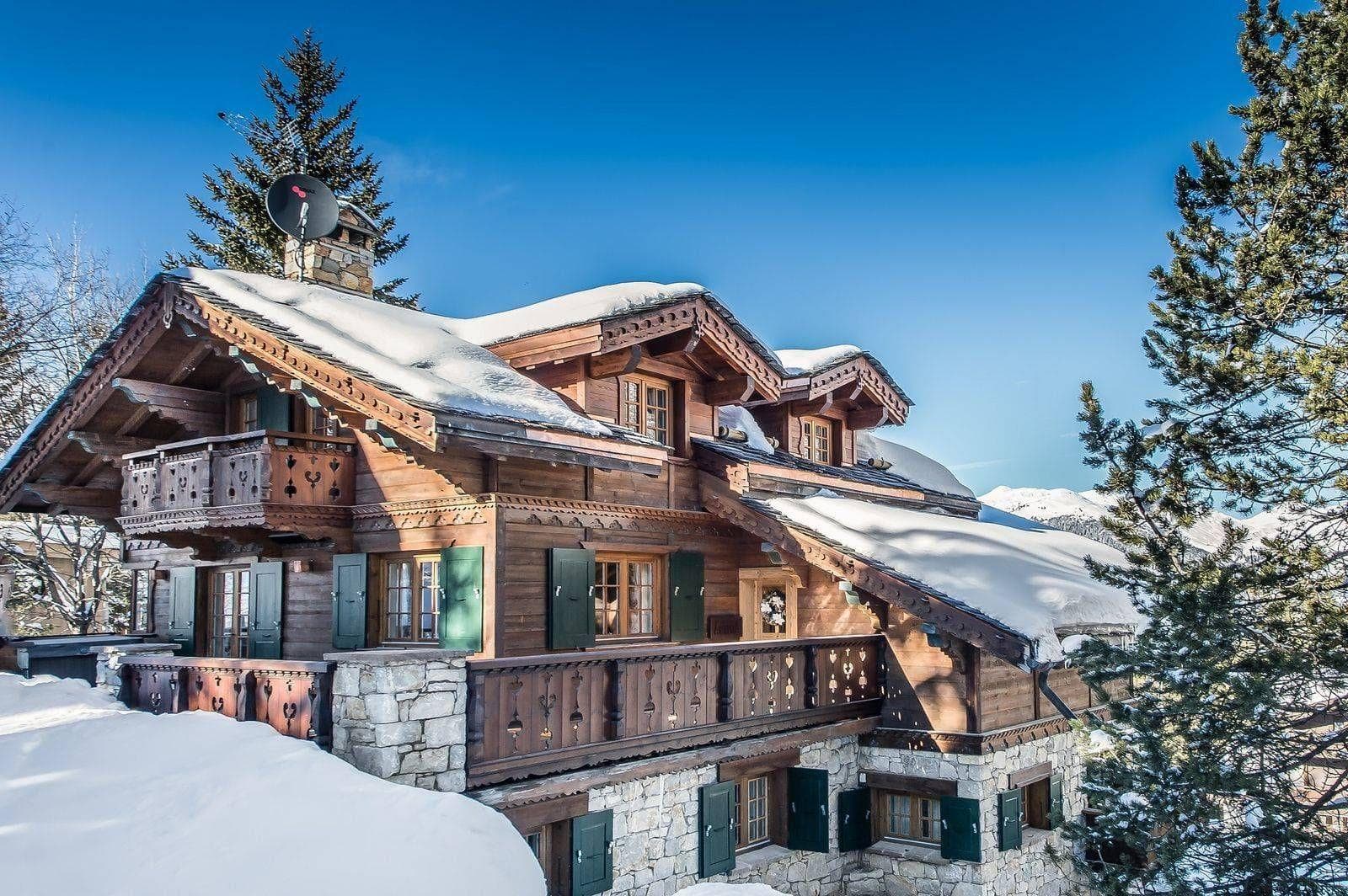 Alpine chalet exterior with multiple balconies and traditional stone masonry
