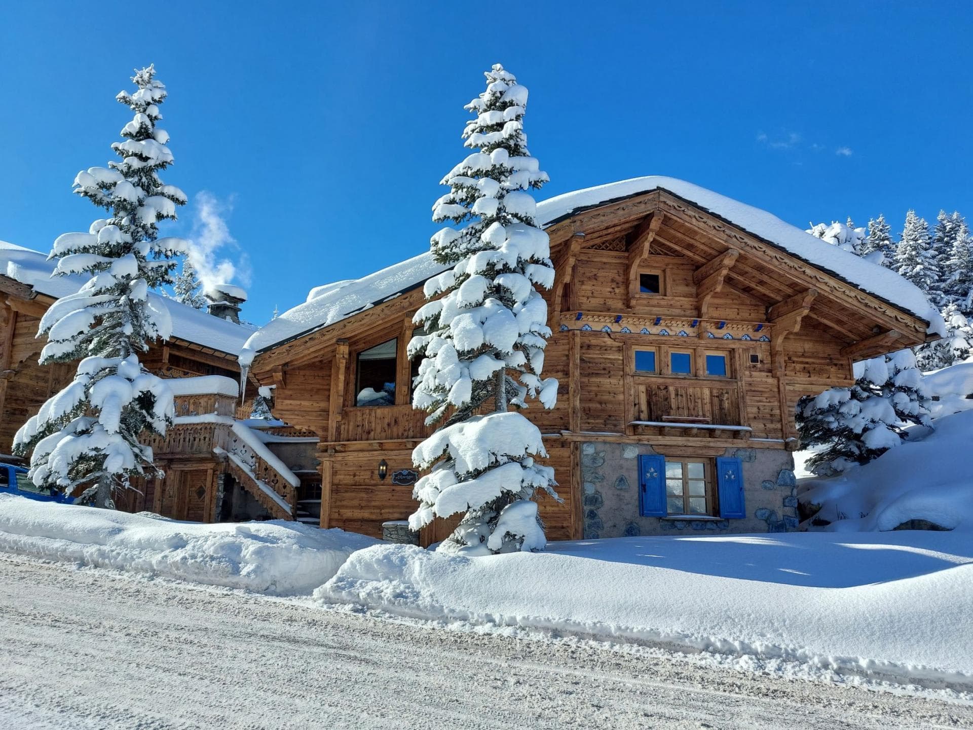 Ski-in, ski-out timber chalet with stone base and traditional blue shutters