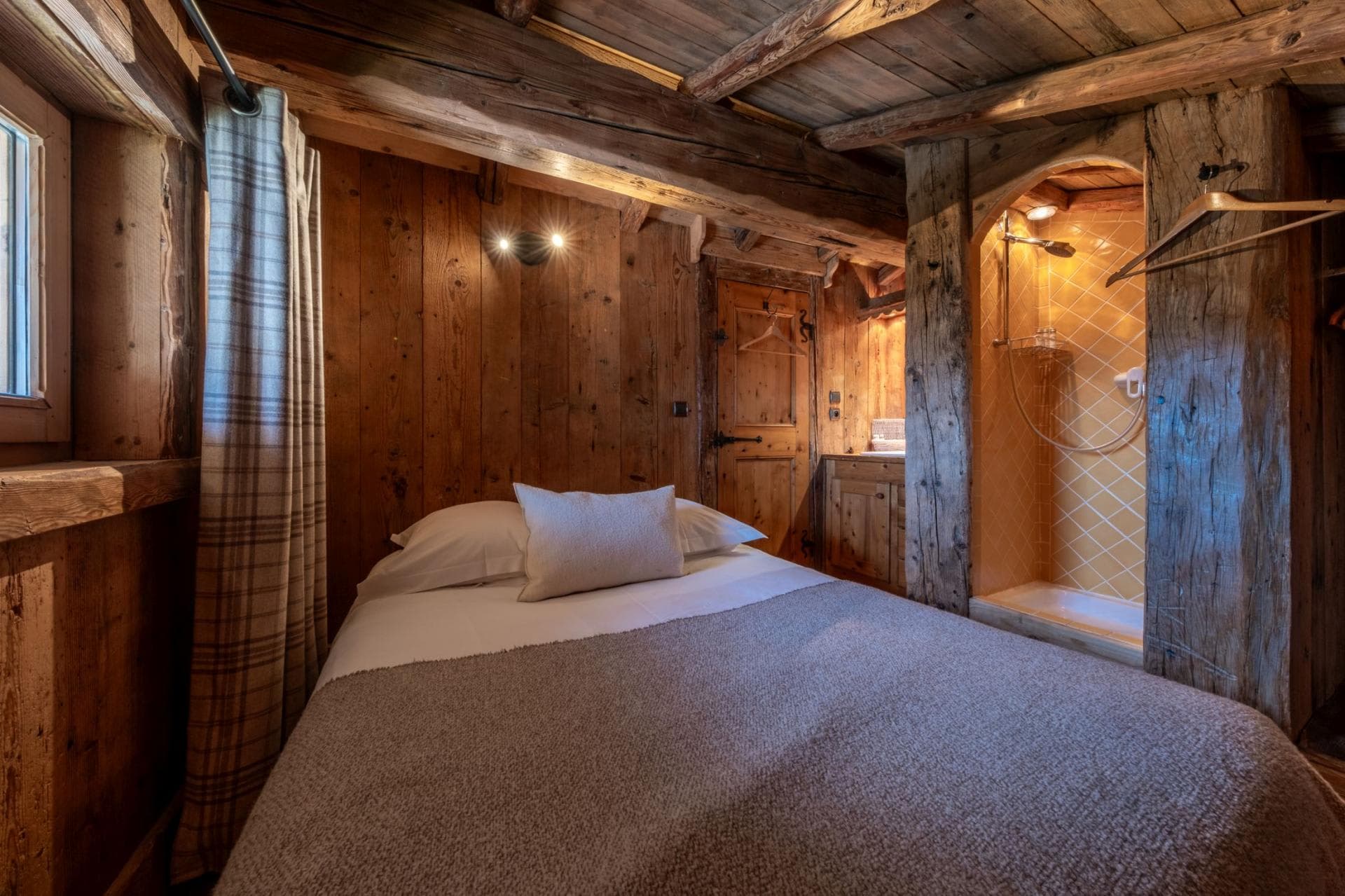 Guest bedroom featuring en-suite walk-in shower and original timber beams