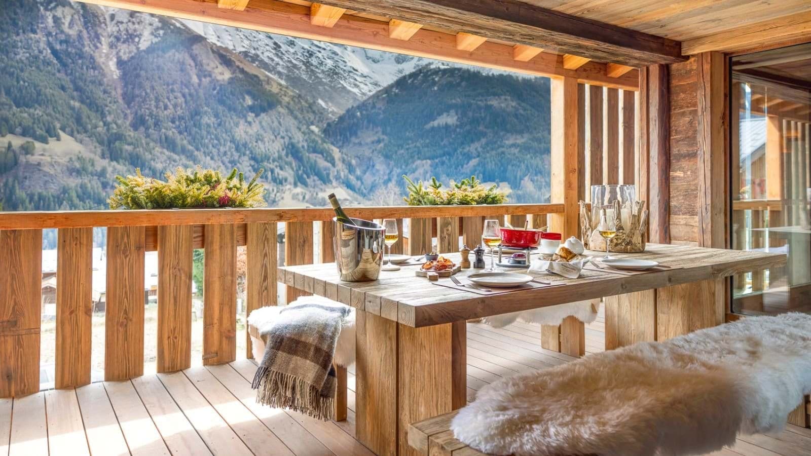 Covered balcony dining area with mountain views and sheepskin bench seating