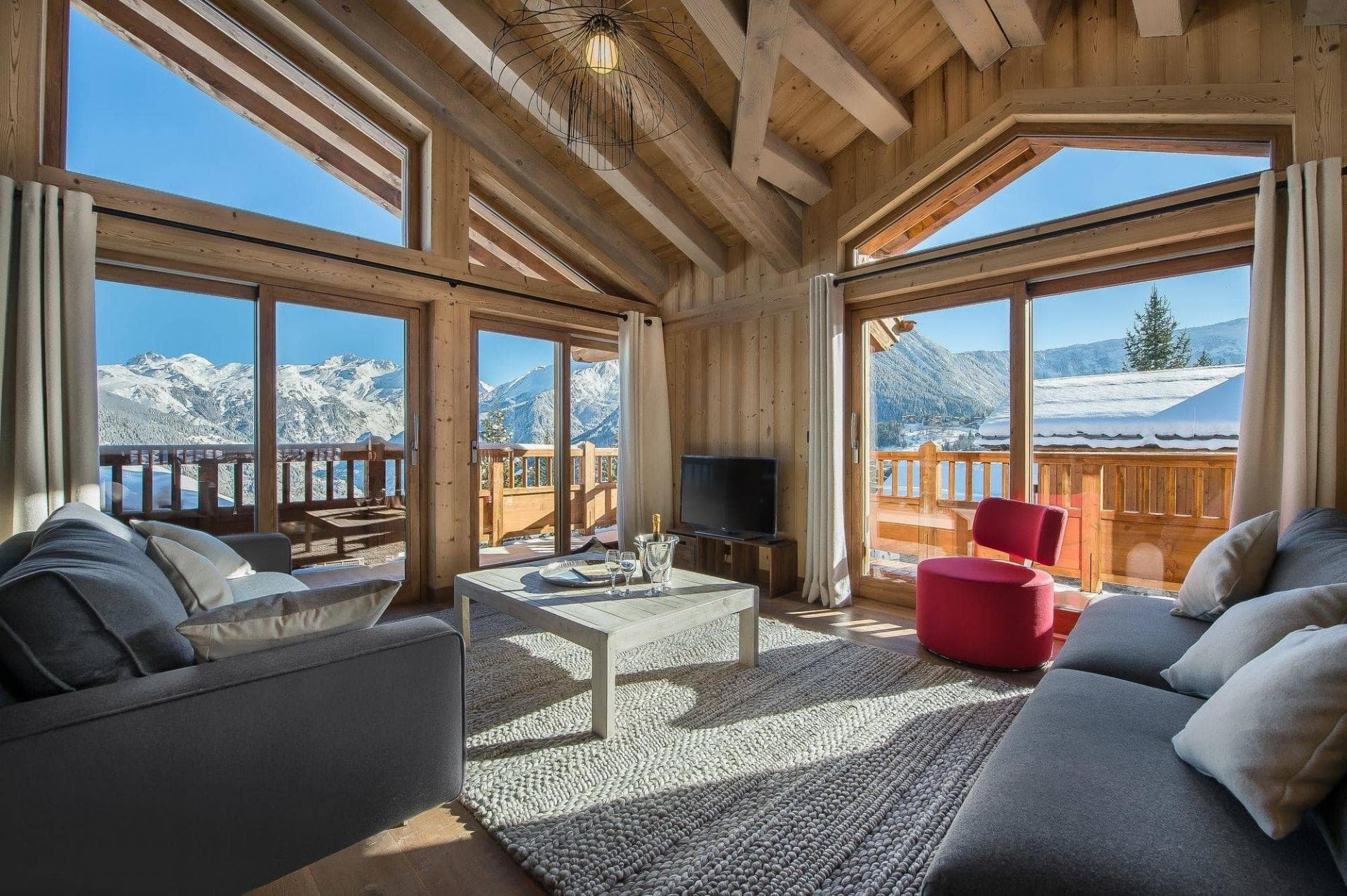 Living area with vaulted timber ceilings and mountain-facing private balcony