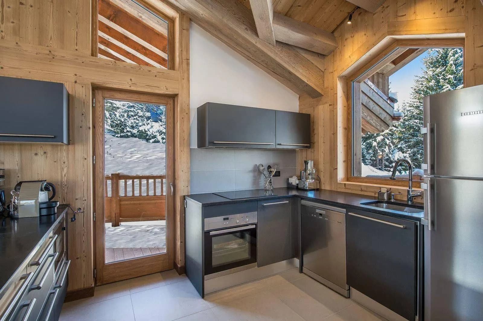 Fitted kitchen with a refrigerator, oven and balcony access