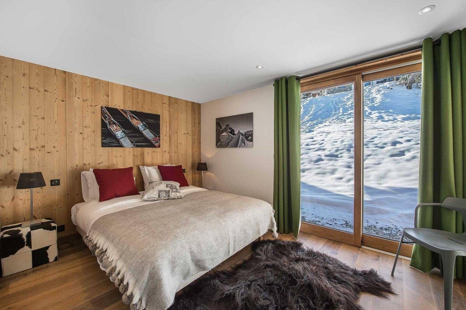 Double bedroom with timber walls and terrace access