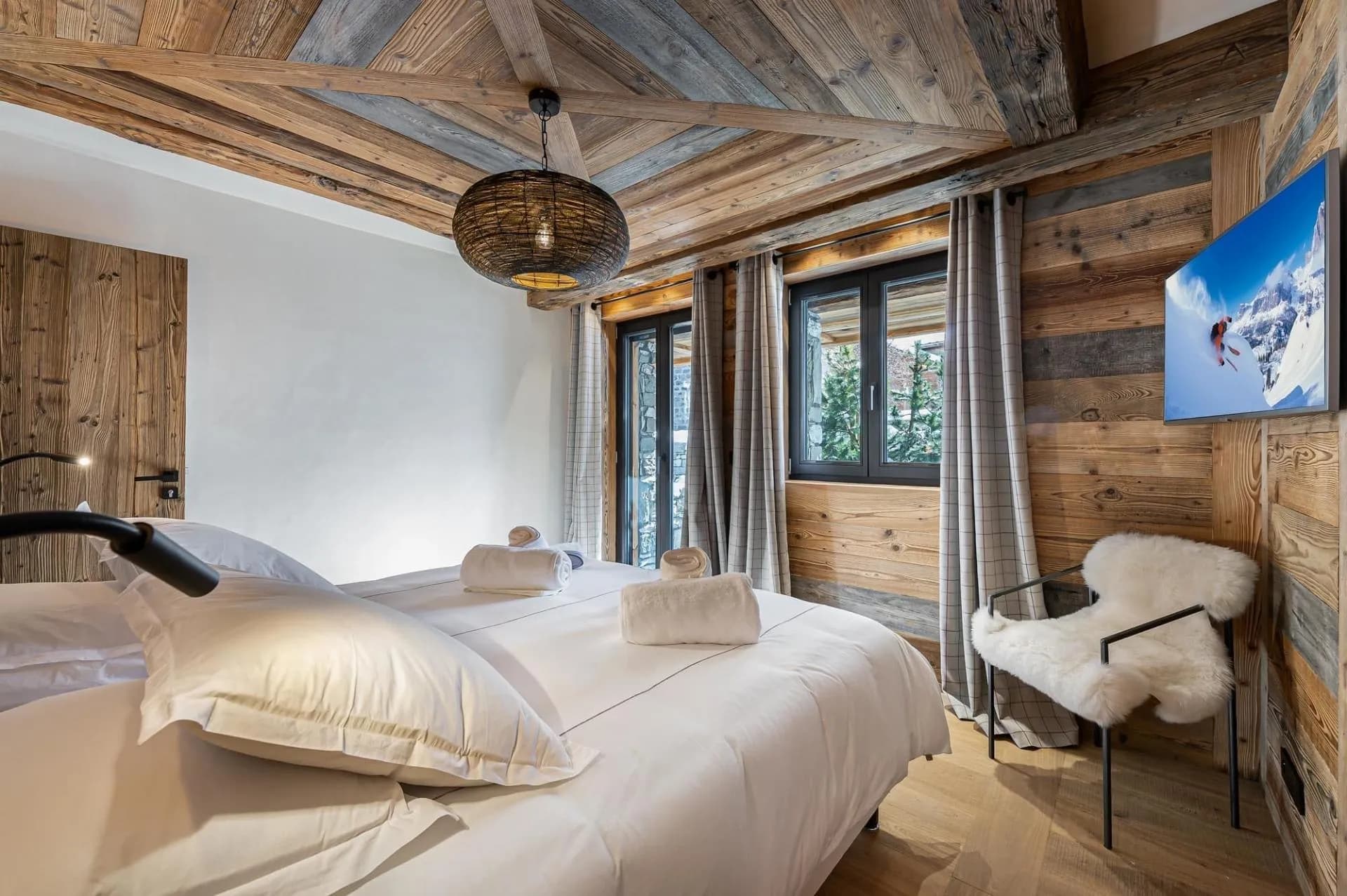 Double bedroom with timber walls and a television
