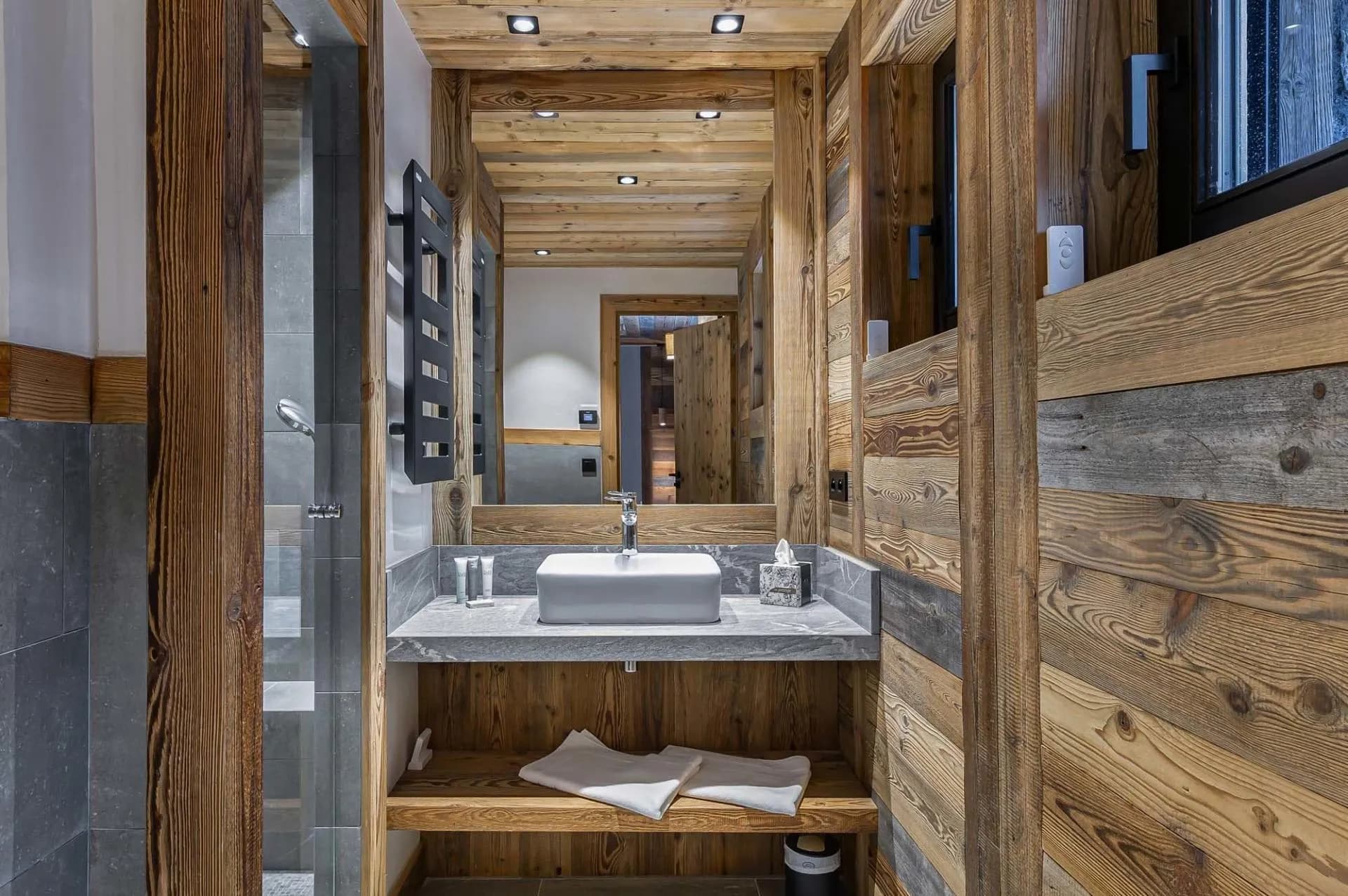 Bathroom vanity beside a shower and heated towel rail