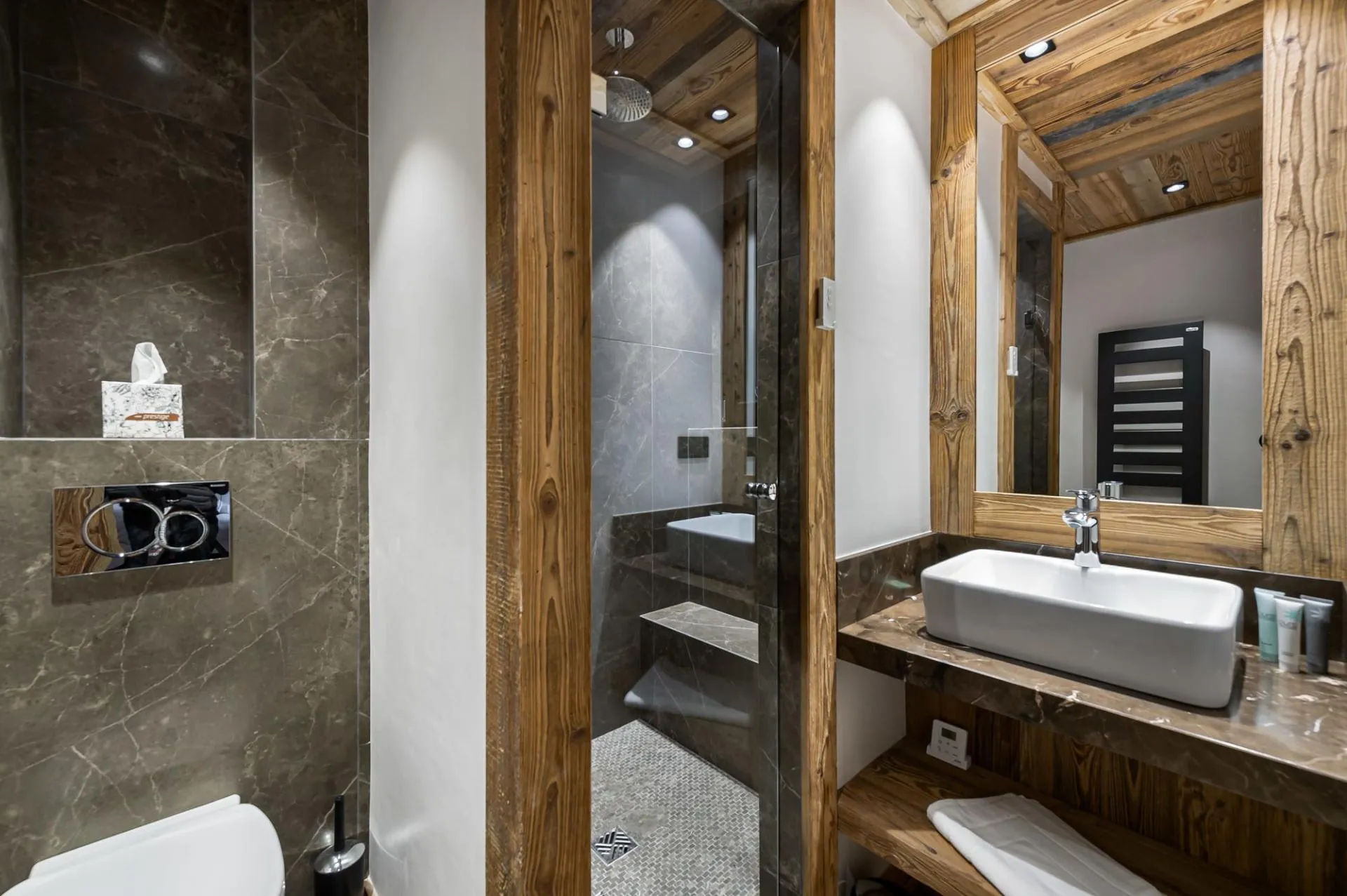 Shower room with a vessel basin and dark stone tiles