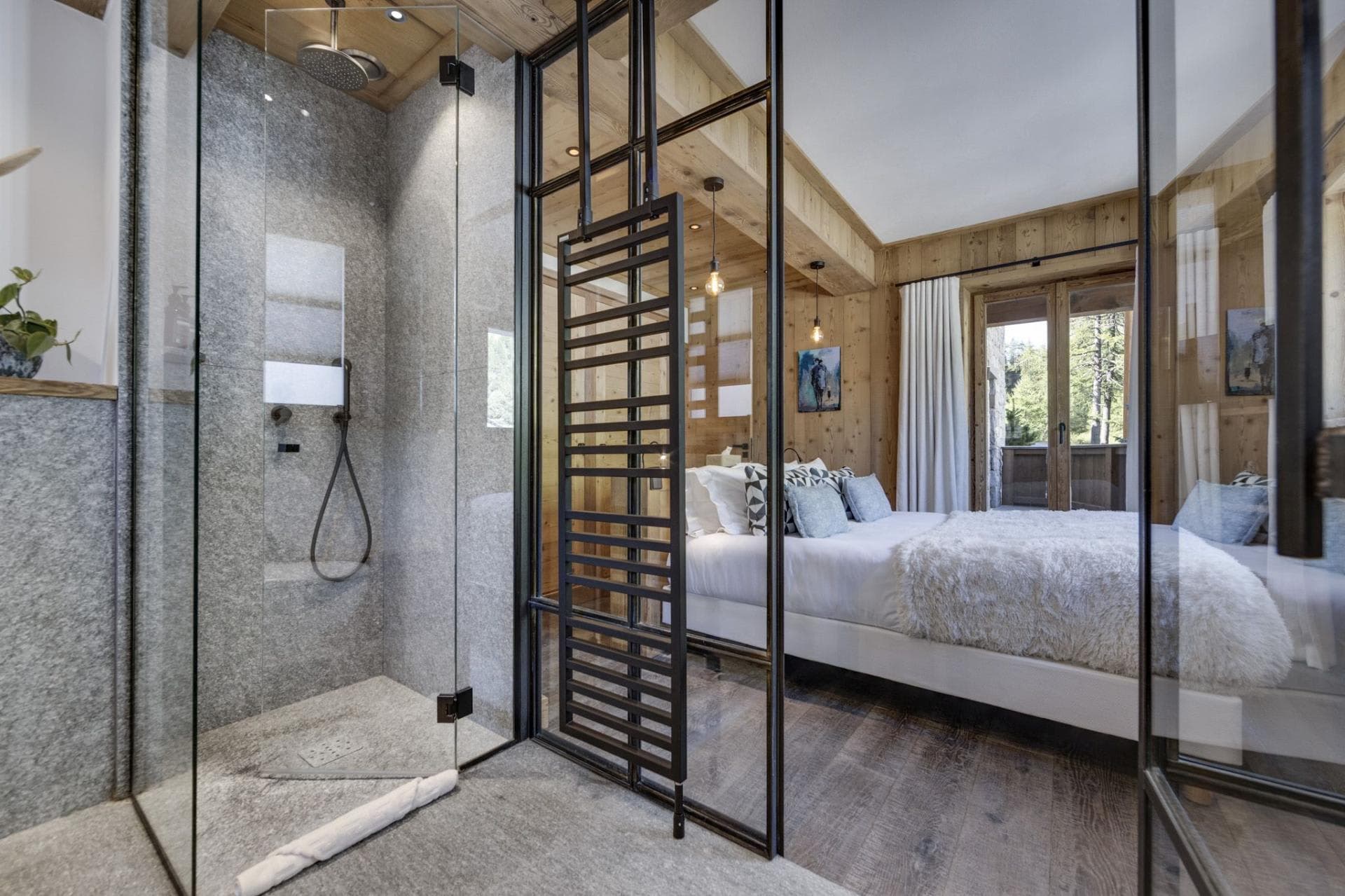 Walk-in stone shower featuring integrated towel rail and bedroom glass partition