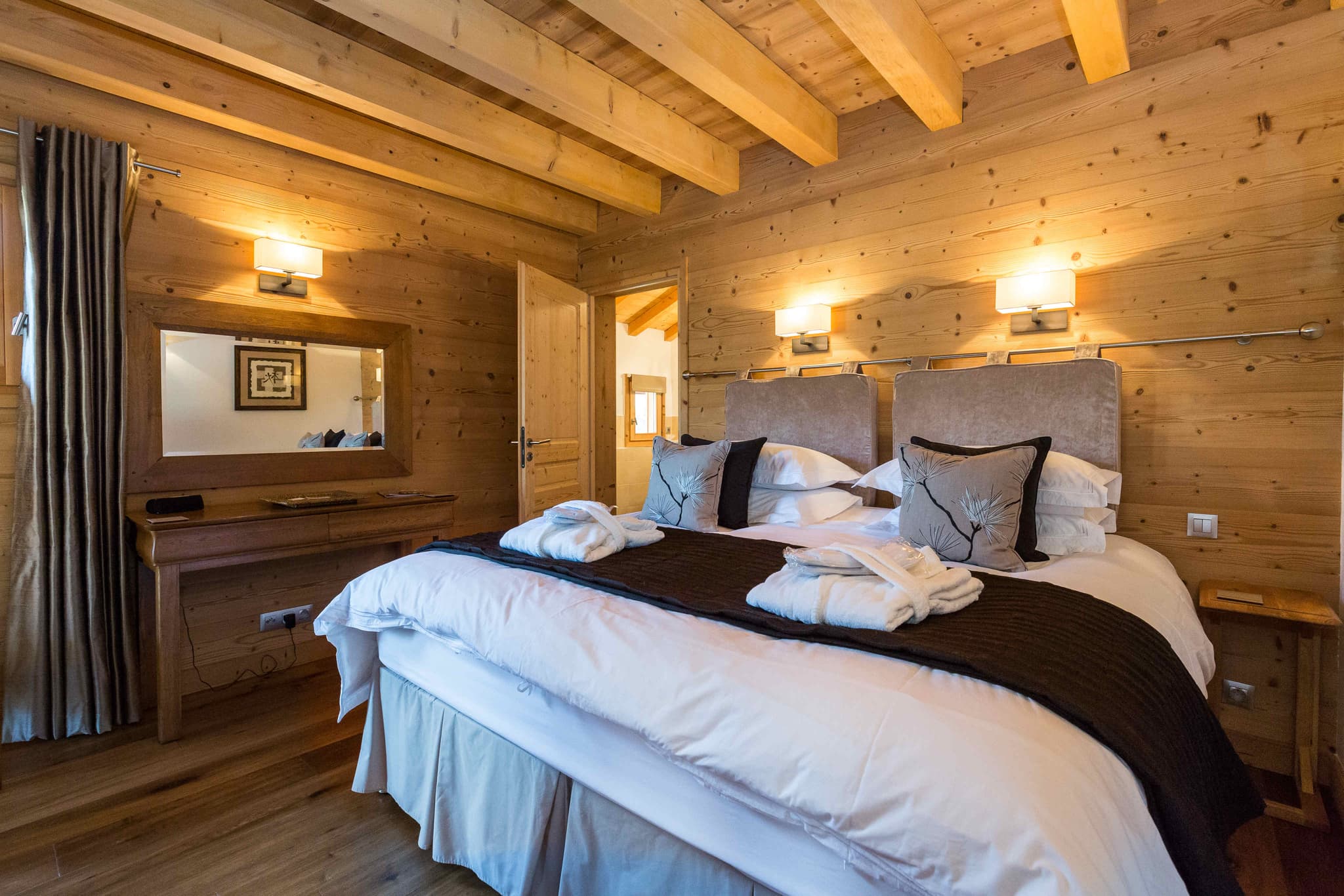 Bedroom with king bed, exposed wood beams, and vanity desk